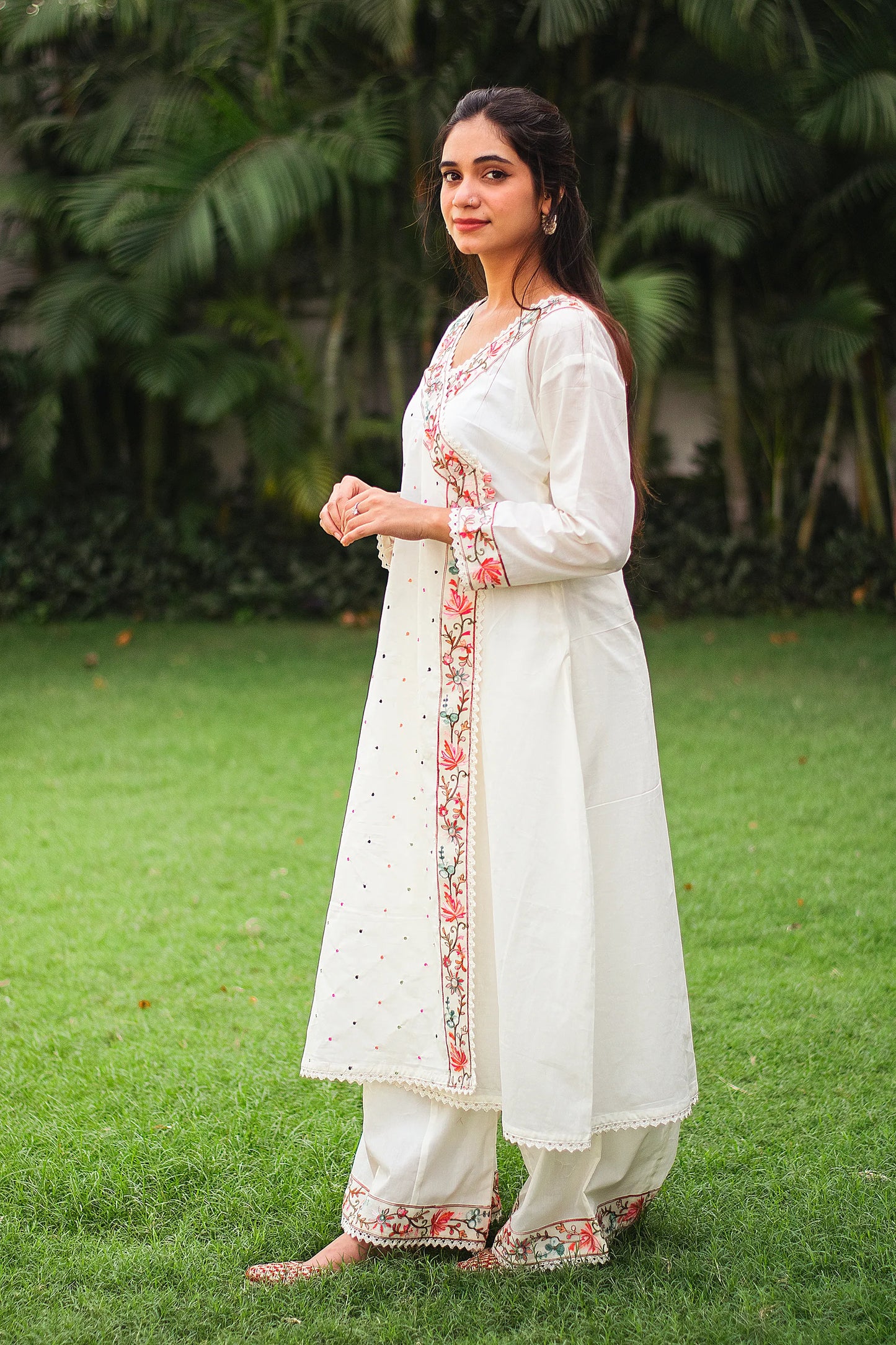 An Indian woman in a graceful pose, wearing an off-white cotton angarkha