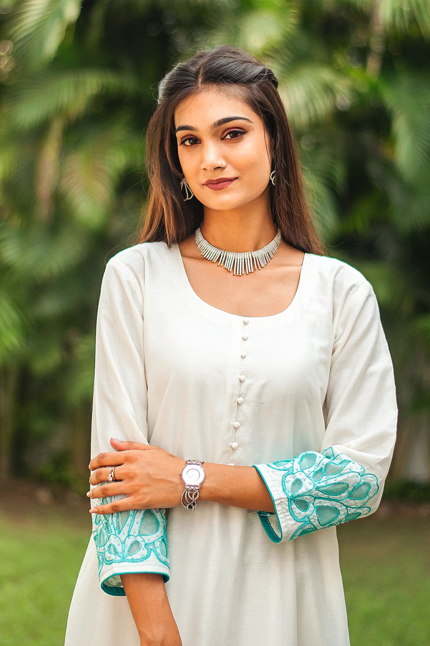 Close-up of the Chanderi fabric and cyan green floral cutwork on the upper half of the suit, as worn by the model