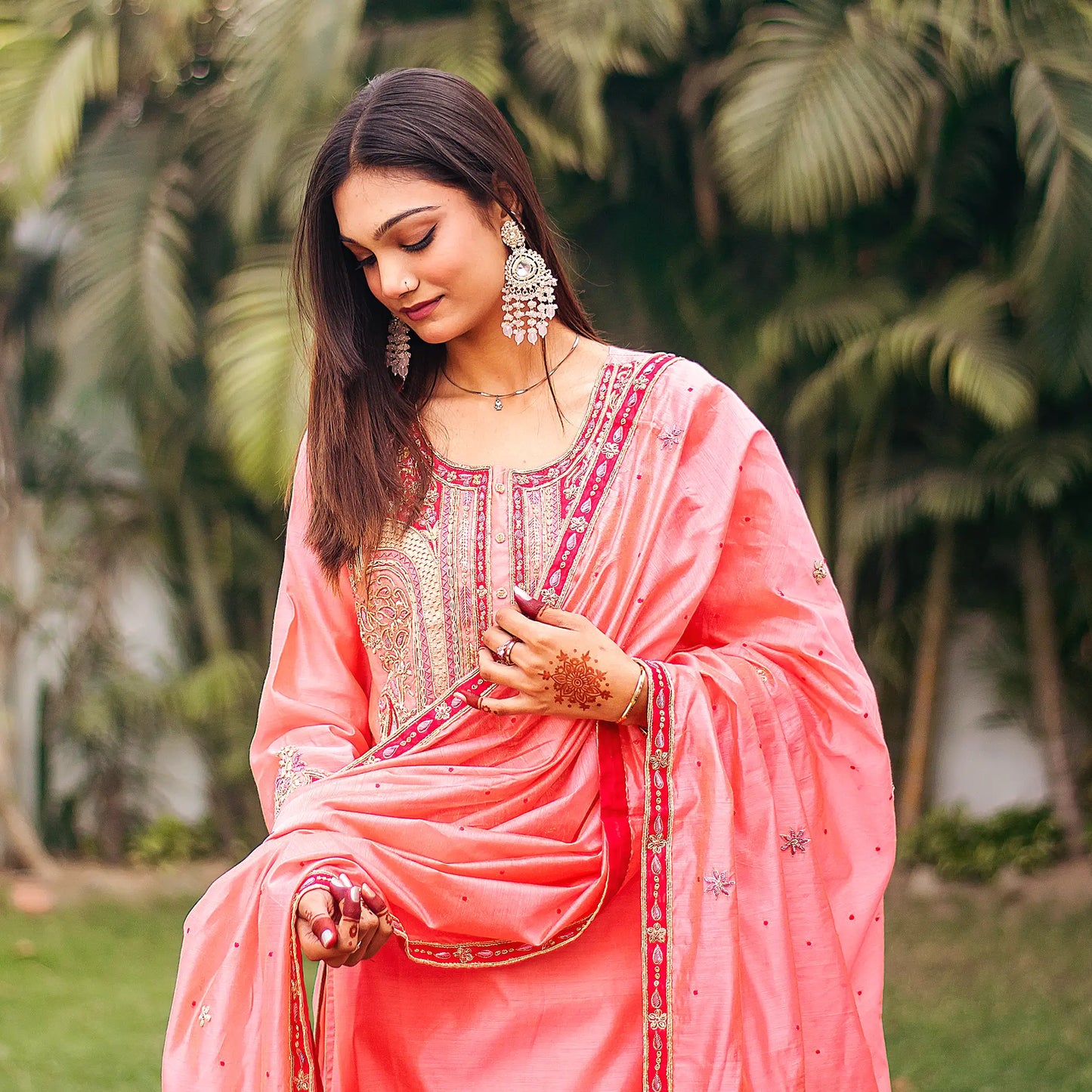 Close-up of an Indian model wearing a peach chanderi kurta with zardozi embroidery, holding a matching dupatta with zardozi flowers.