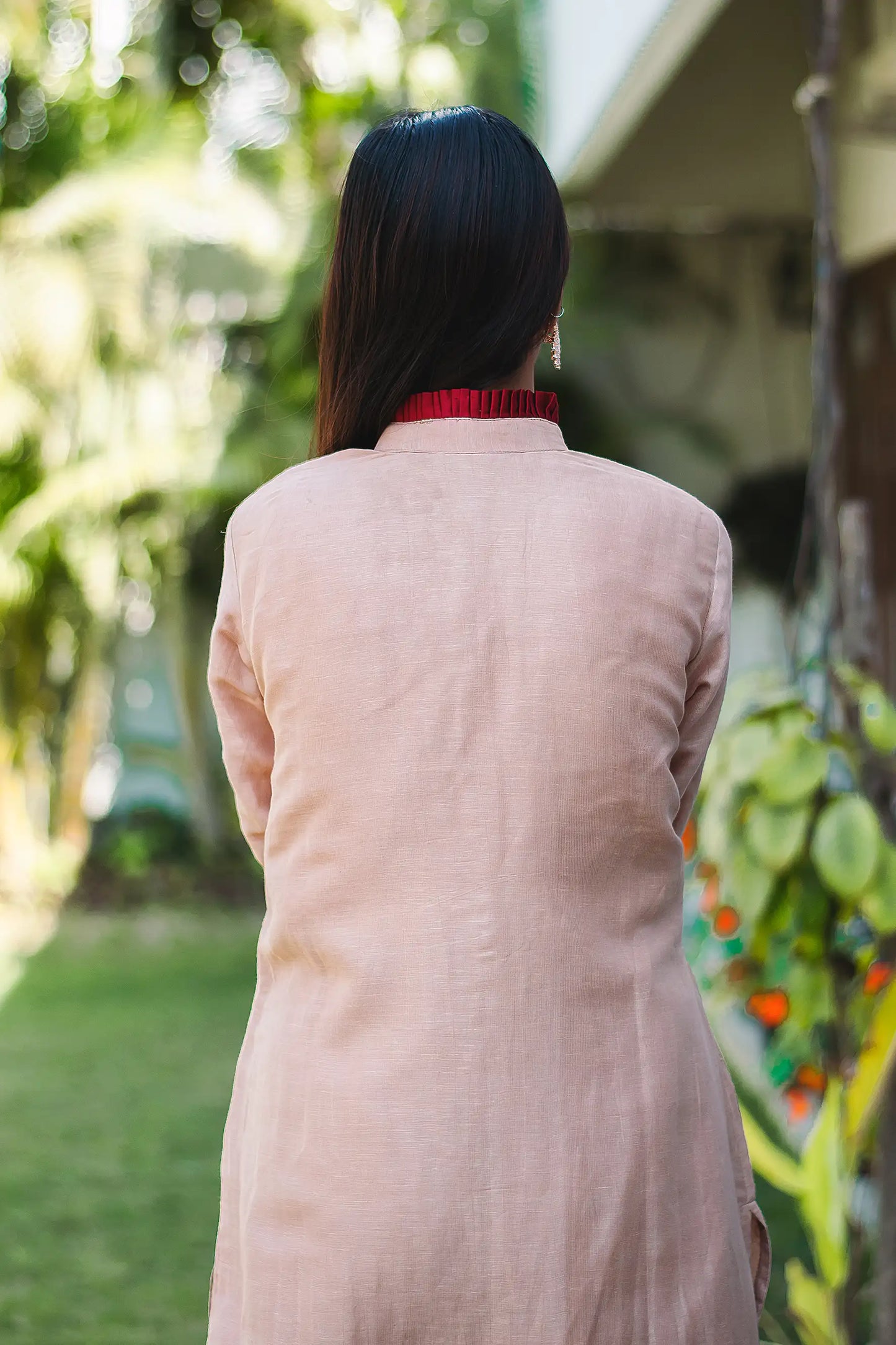 A woman's back in a beige kurta, showing the elegant drape of the linen weave fabric