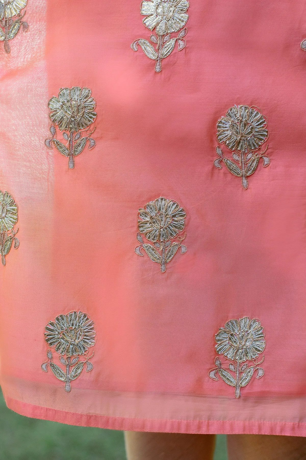 A lady dressed in a Peach Chanderi Kurta and Dupatta with stunning Gota Work, matched with a Golden Churidar.