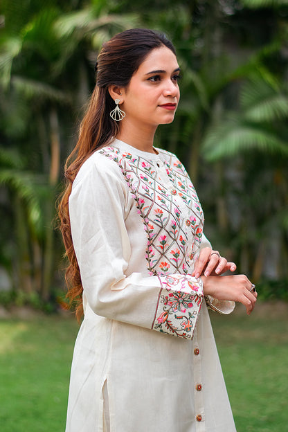 Close up of side profile of an Indian girl wearing an off-white front-open kurti with Kashmiri embroidery.