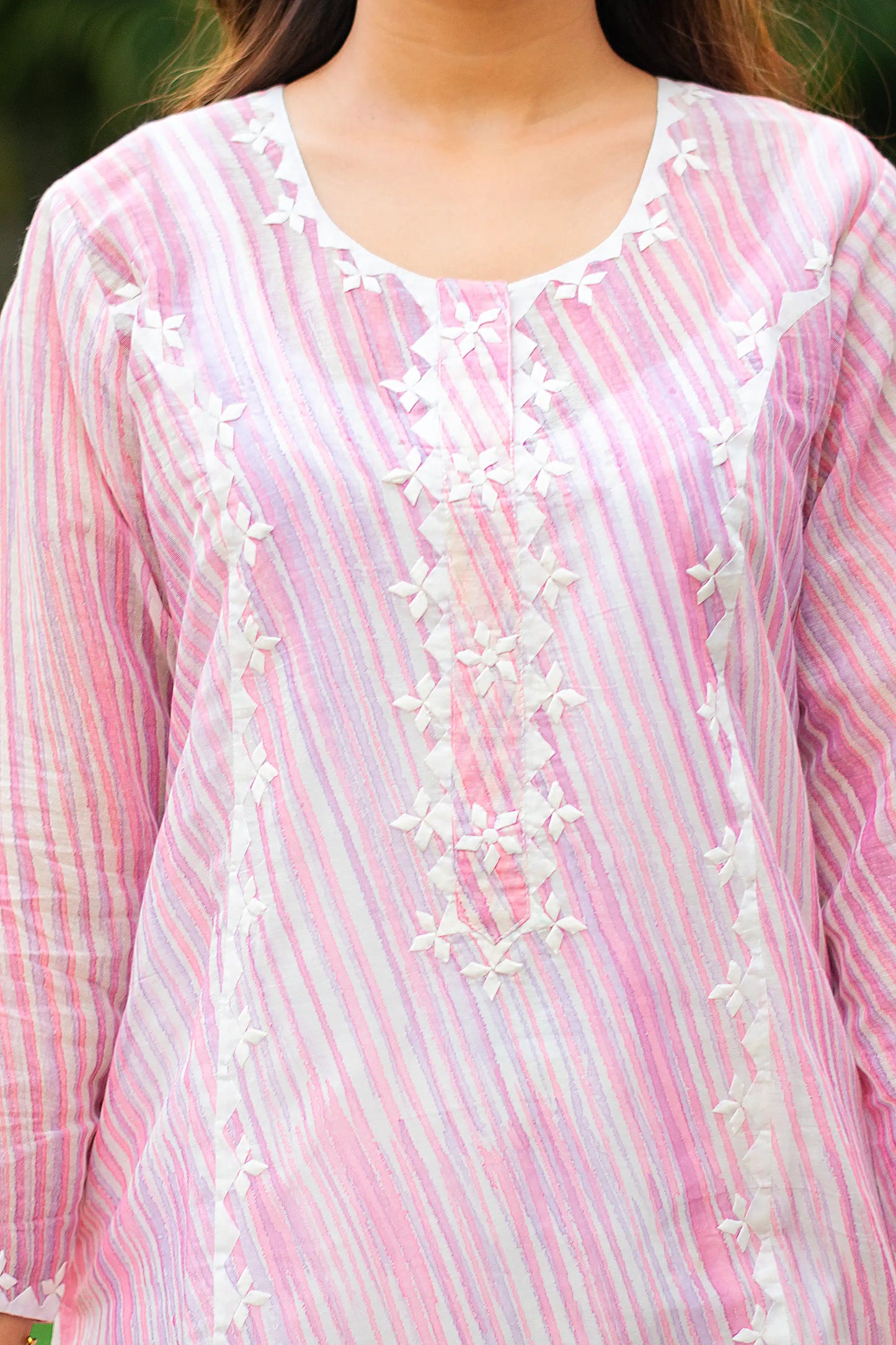 Close-up of off-white applique work on the yoke of the light pink kurta.