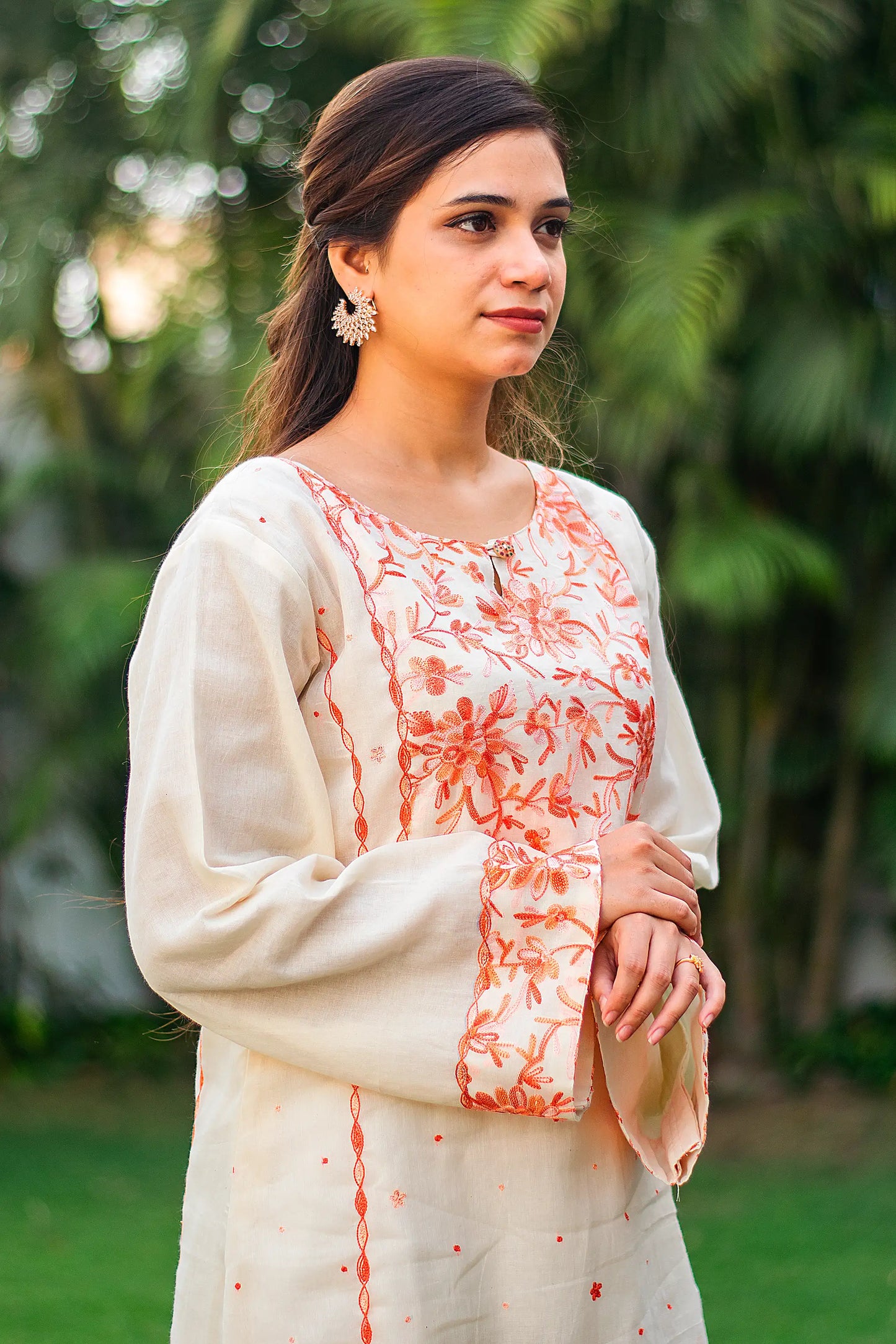 ndian model in a side profile, highlighting the peach embroidered kurta.