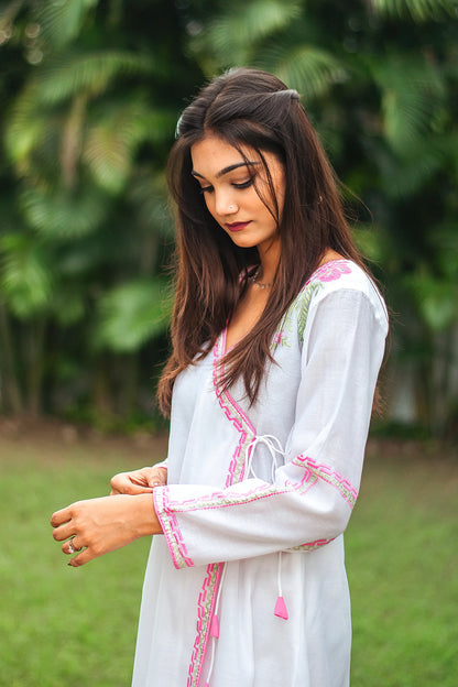 Side view of an Indian model in a white chanderi angrakha kurta featuring pink floral and green leaf embroidery. 