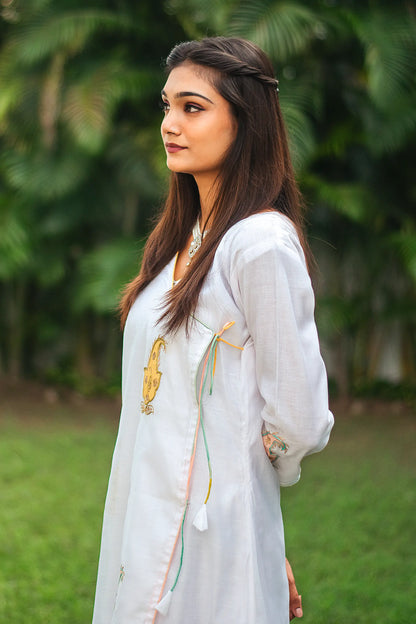 Side view of an Indian model wearing a white chanderi angarkha kurta with kairi (paisley) patchwork.