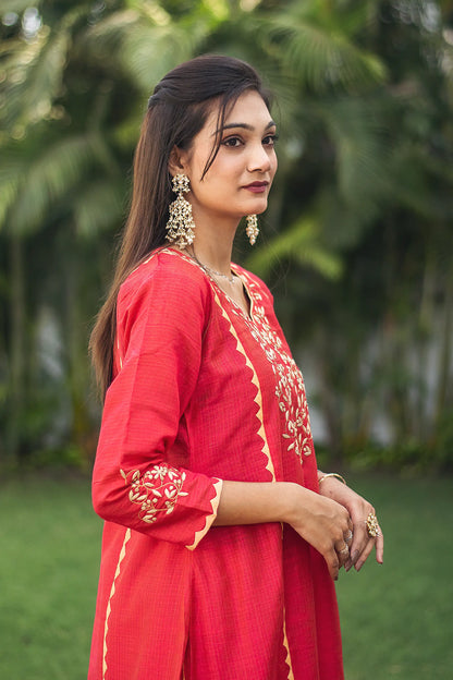 Indian model in a side pose, highlighting the red kurta with beige applique.