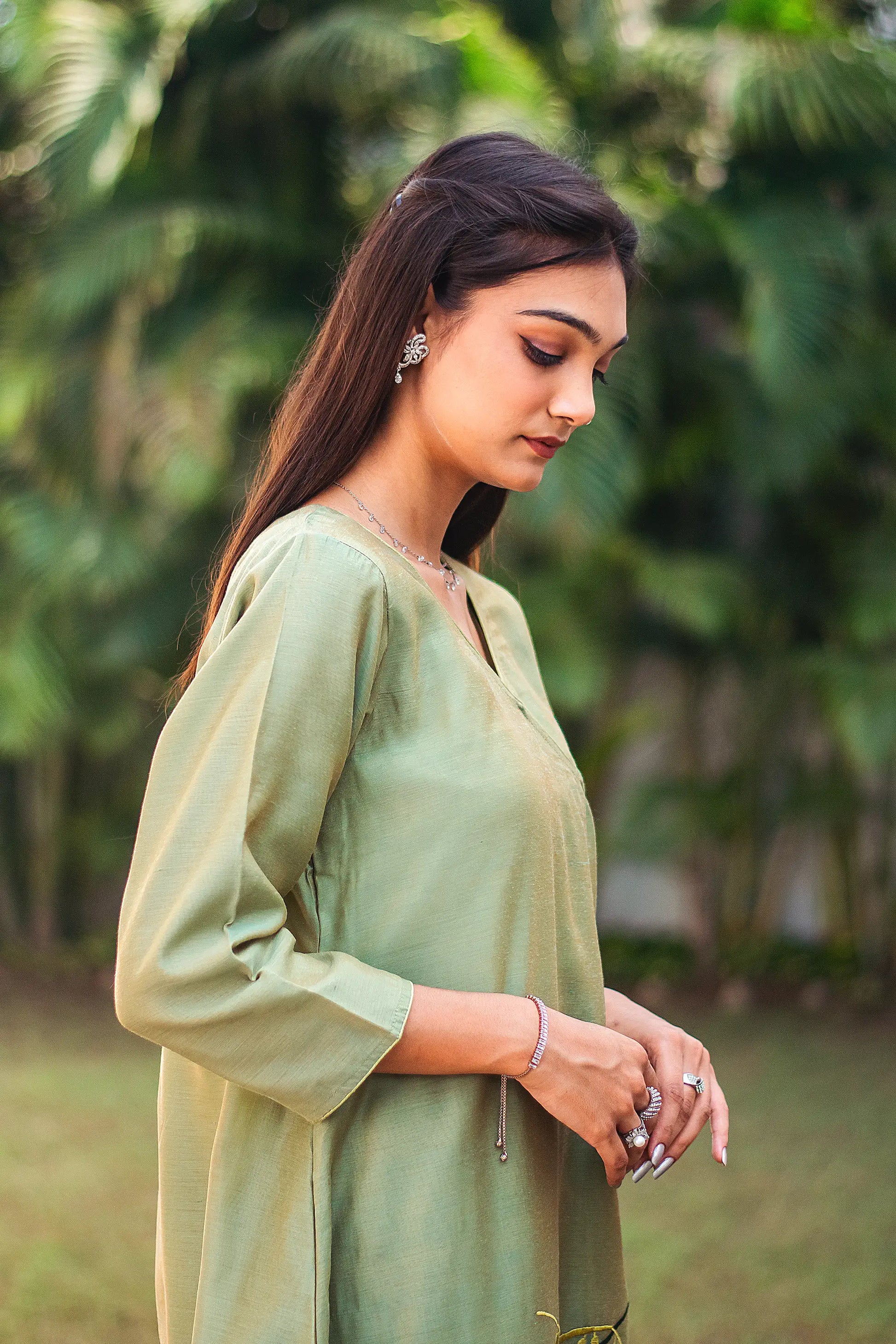 Upper right side view of a model wearing the green kurta set, highlighting the angrakha’s silhouette