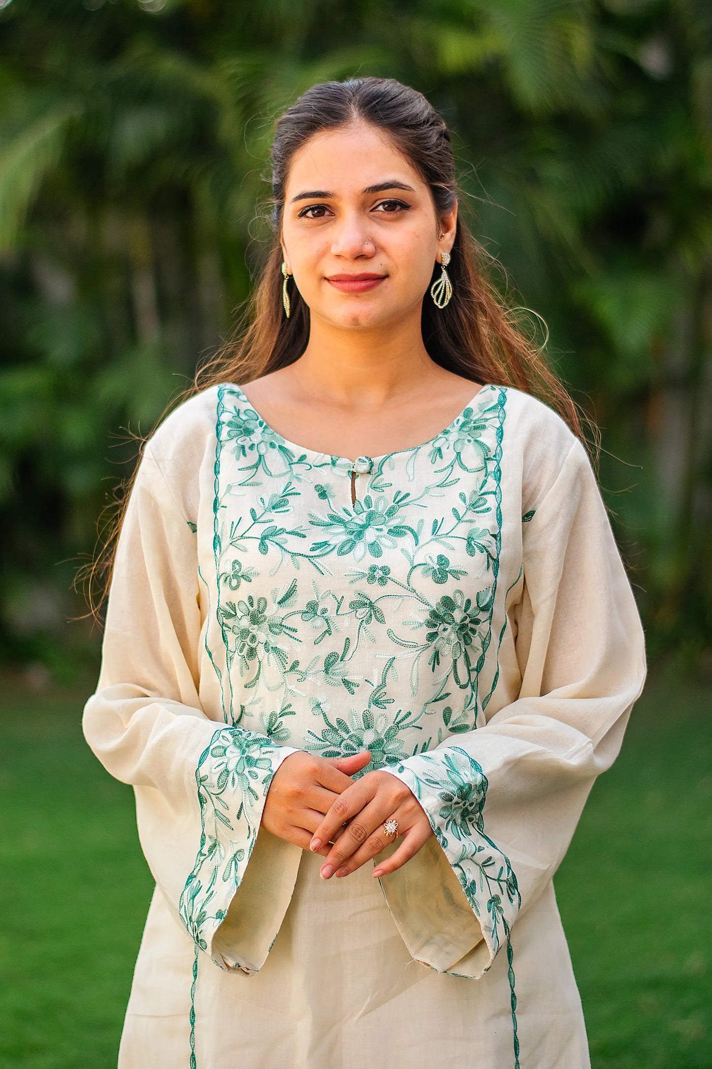 Close-up of an Indian model, highlighting the green floral Kashmiri embroidery on the yoke of the kurta.