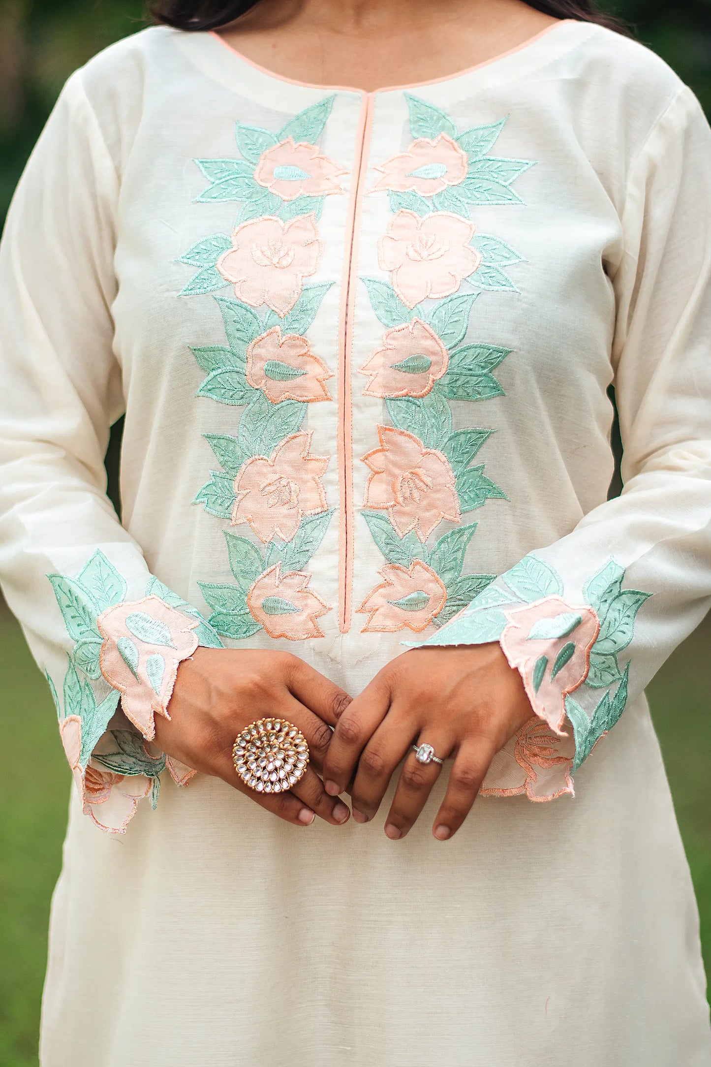 Close-up of peach floral patchwork on the yoke of a cream chanderi kurta.