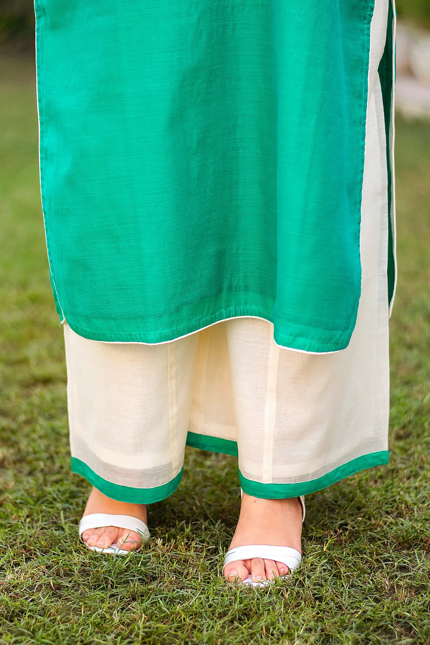 An Indian girl in a pose with only lower half green chanderi kurti and palazzo are visible.