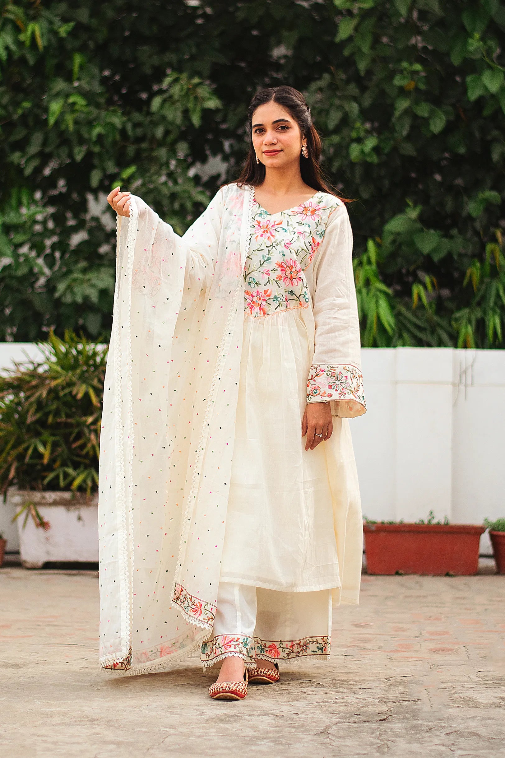 An Indian girl wearing an off-white cotton frock kurta with matching palazzo pants and dupatta