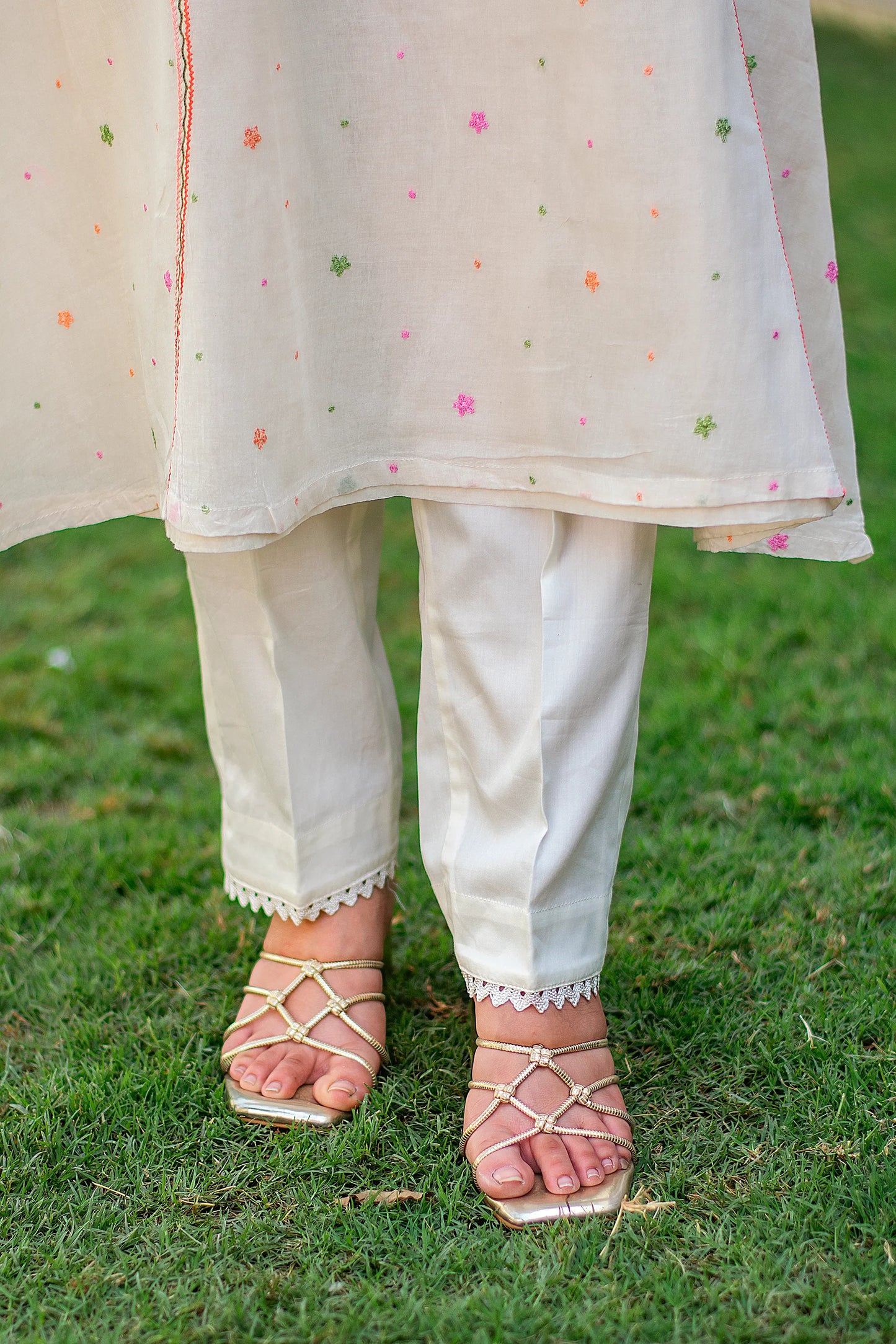 Close-up of an Indian model in plain off-white Russian silk trousers, part of the Kashmiri embroidered kurta set.