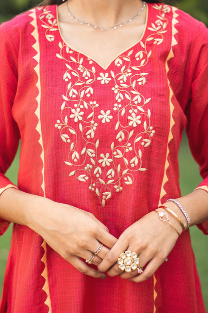 Close-up of the beige applique work on the yoke of the red jute silk kurta.