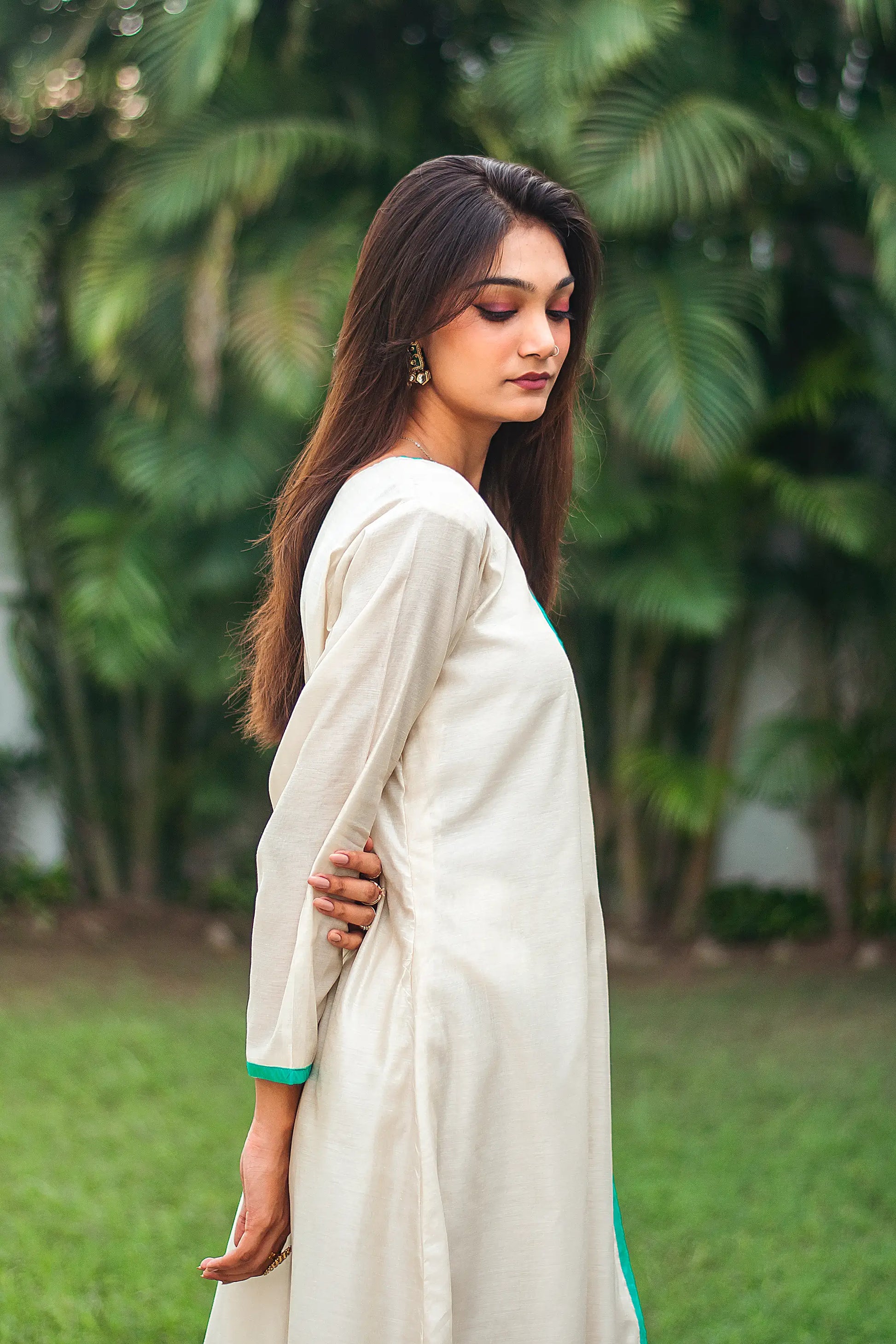 Upper right side view of a model wearing the beige chanderi angrakha set, highlighting the timeless angrakha silhouette
