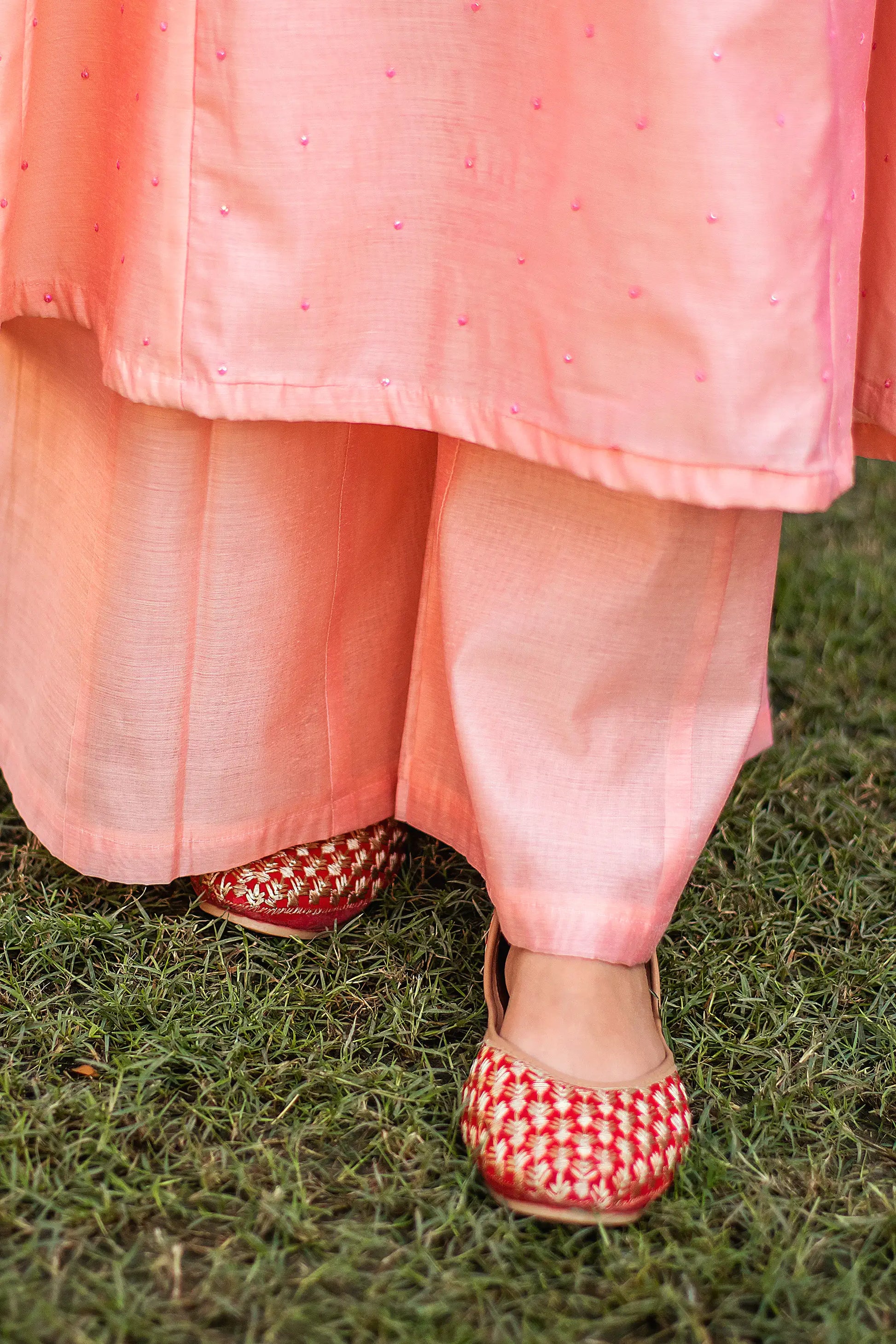 Close-up of the peach palazzo trousers in Chanderi fabric, paired with the peach kurta.