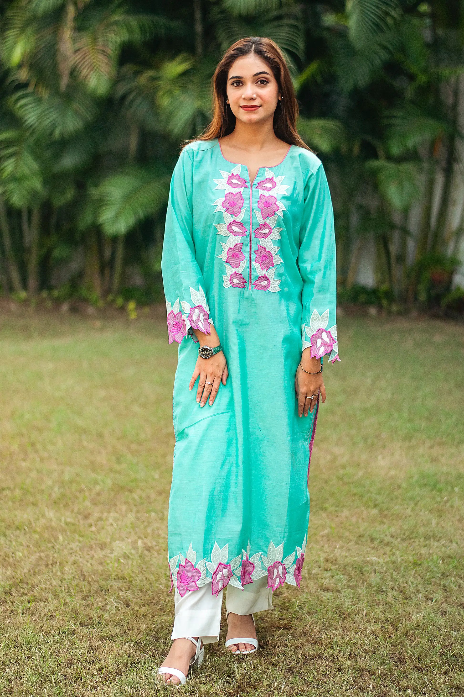 Indian model in a blue chanderi kurta with purple patchwork flowers, paired with off-white trousers.