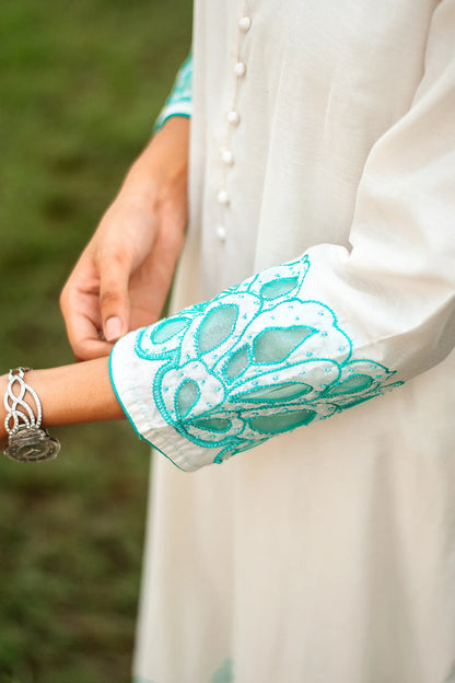 Close-up of the Chanderi kurta's full sleeves with cyan green floral cutwork, worn by the model