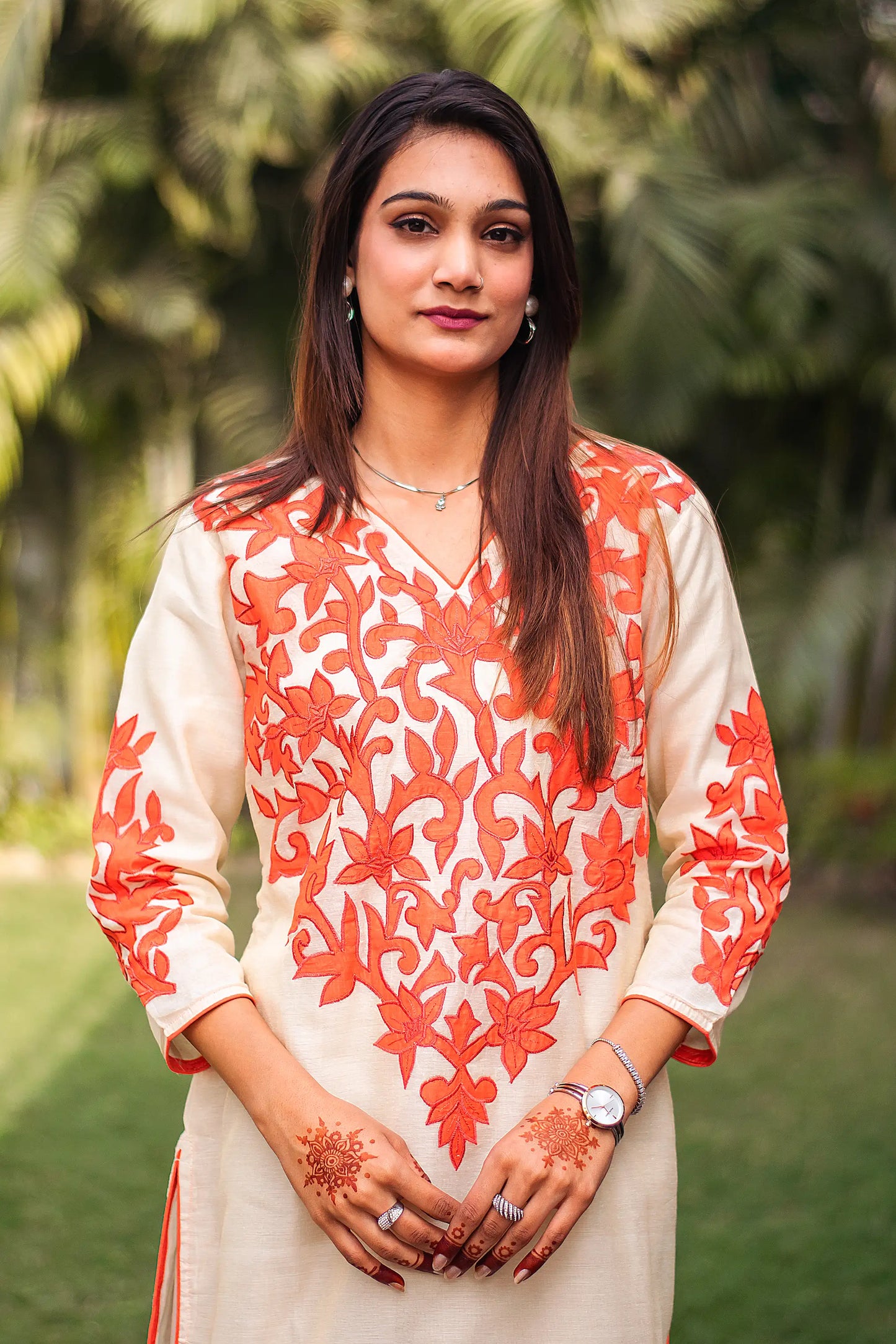 highlighted.	Zoomed-in view highlighting the orange floral patchwork on the yoke of the beige chanderi kurta.