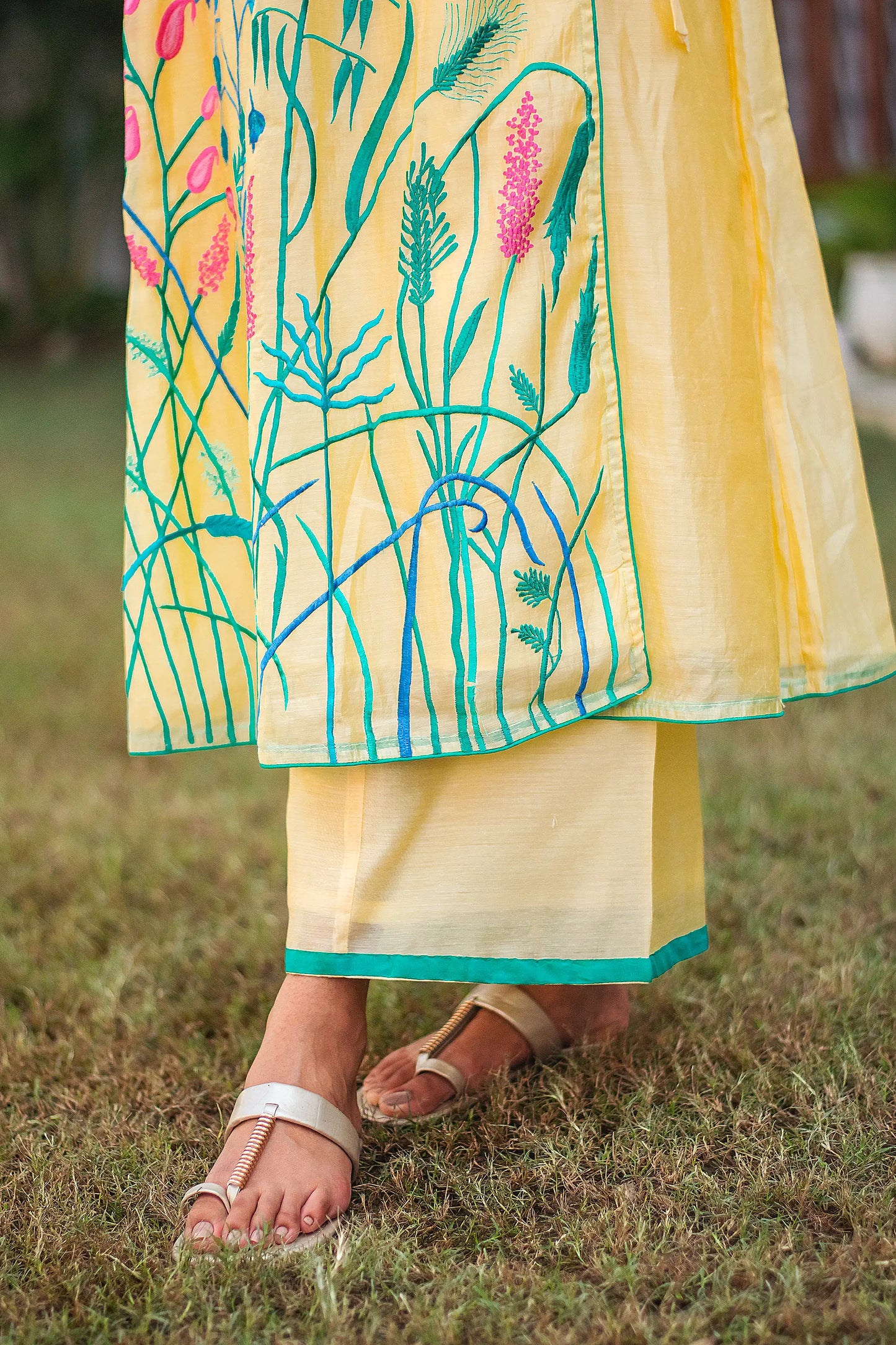 Close-up of the vibrant resham floral embroidery on the yellow angrakha kurta.