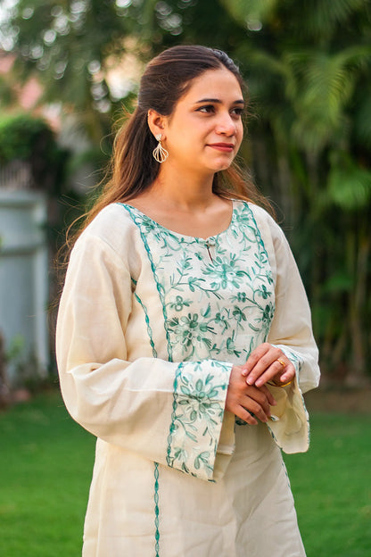 Indian model in a side profile, highlighting the kalidar kurta with floral green thread work.