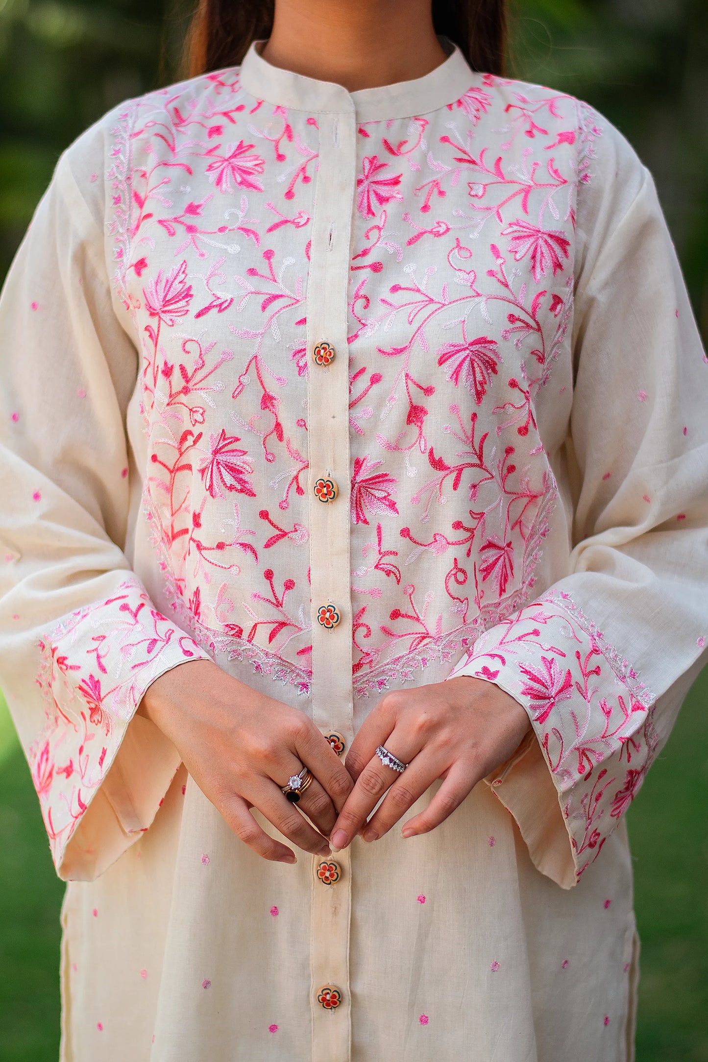 Close-up of Kashmiri floral embroidery on the yoke of the off-white kurta.