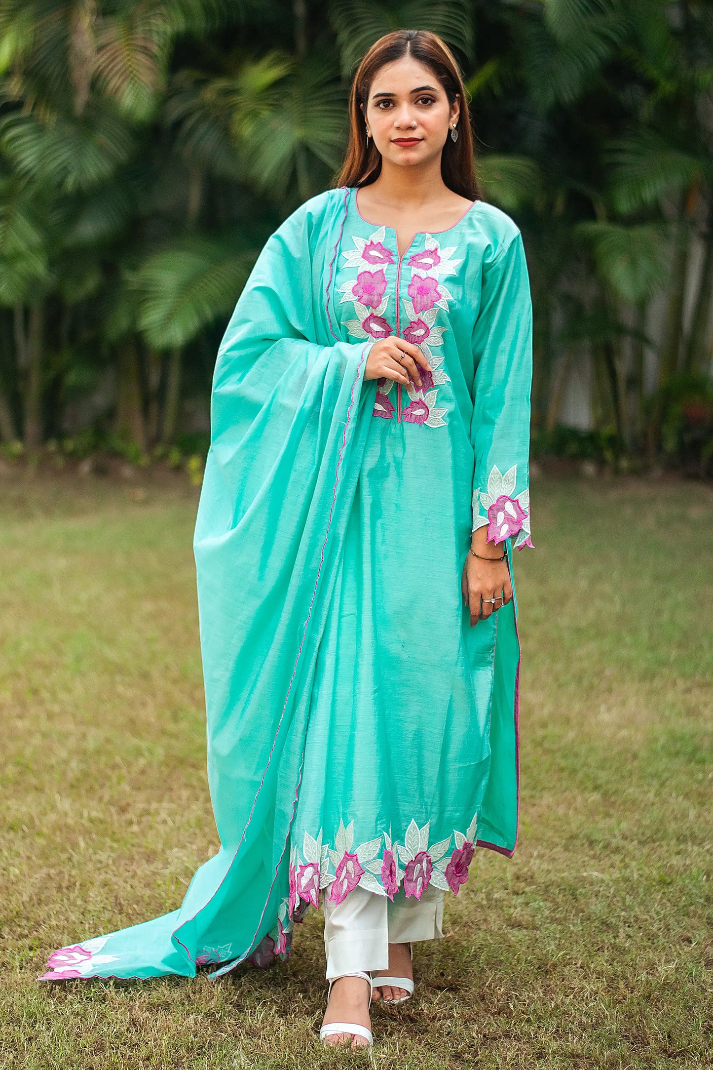 An Indian model poses  in a blue chanderi kurta with purple floral patchwork, paired with a matching dupatta and off-white trousers