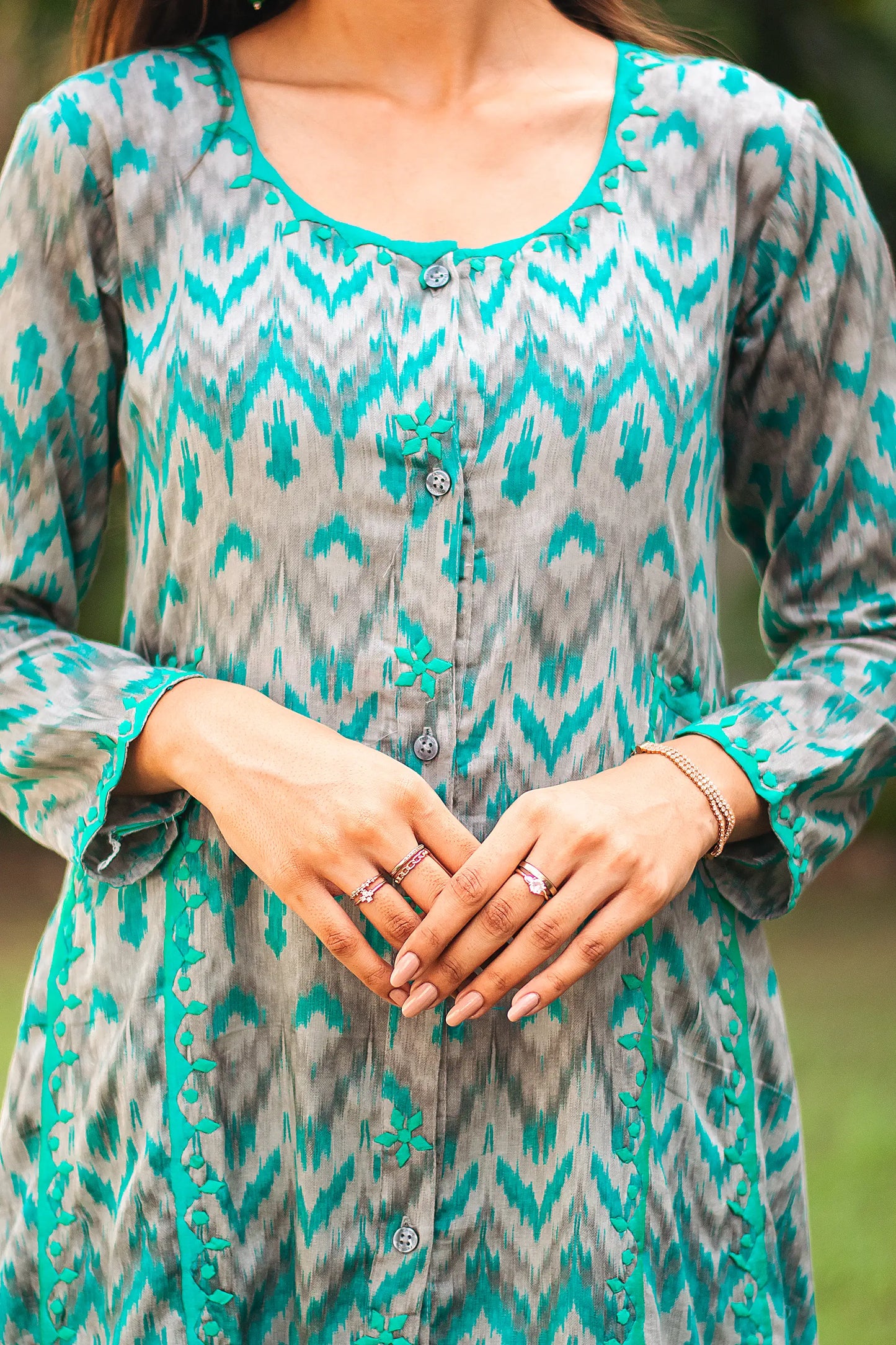 Close-up of the delicate green applique work on the yoke of the grey and green ikat print kurta.