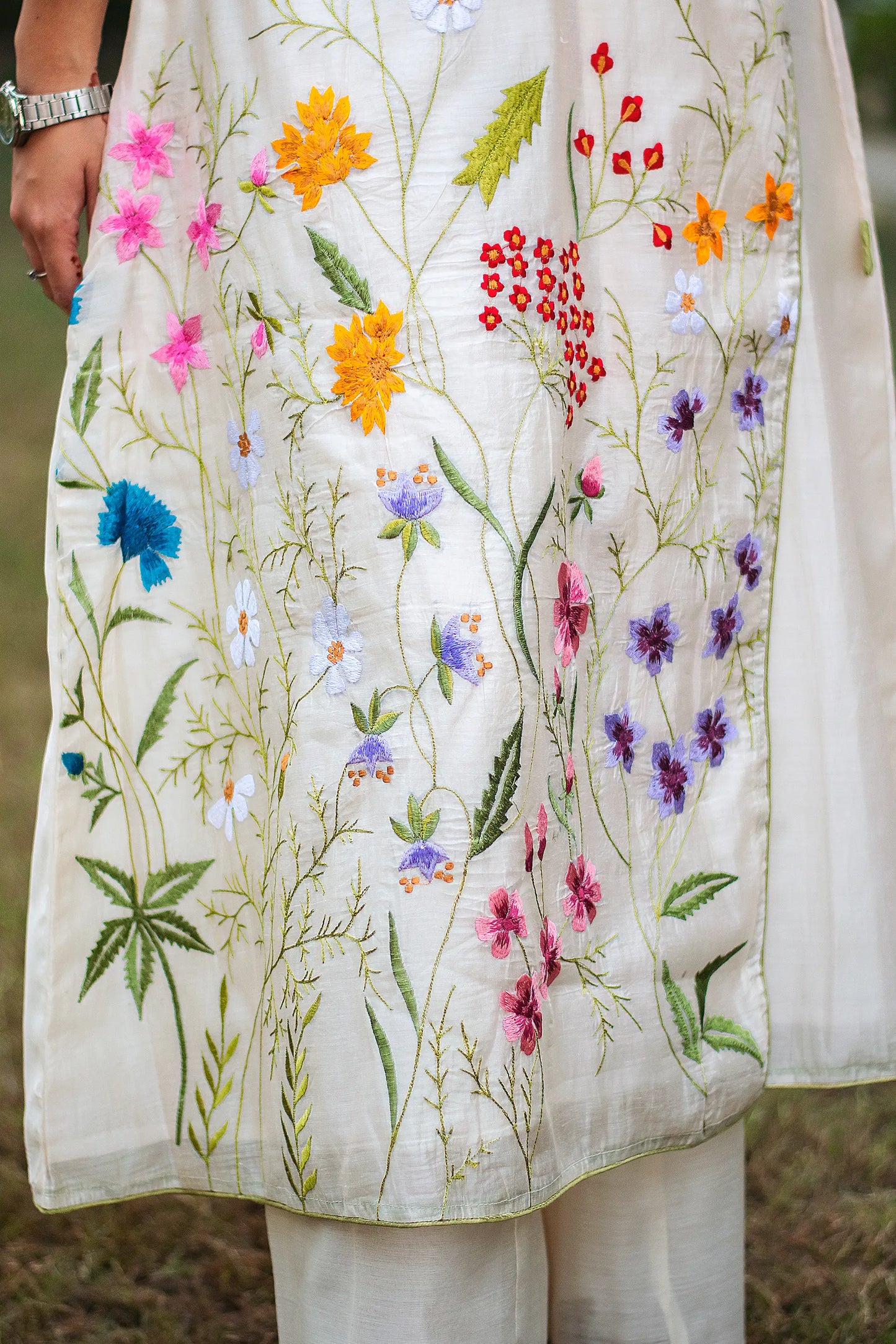 Zoomed-in view highlighting the colorful resham floral motifs on the off-white angrakha kurta.