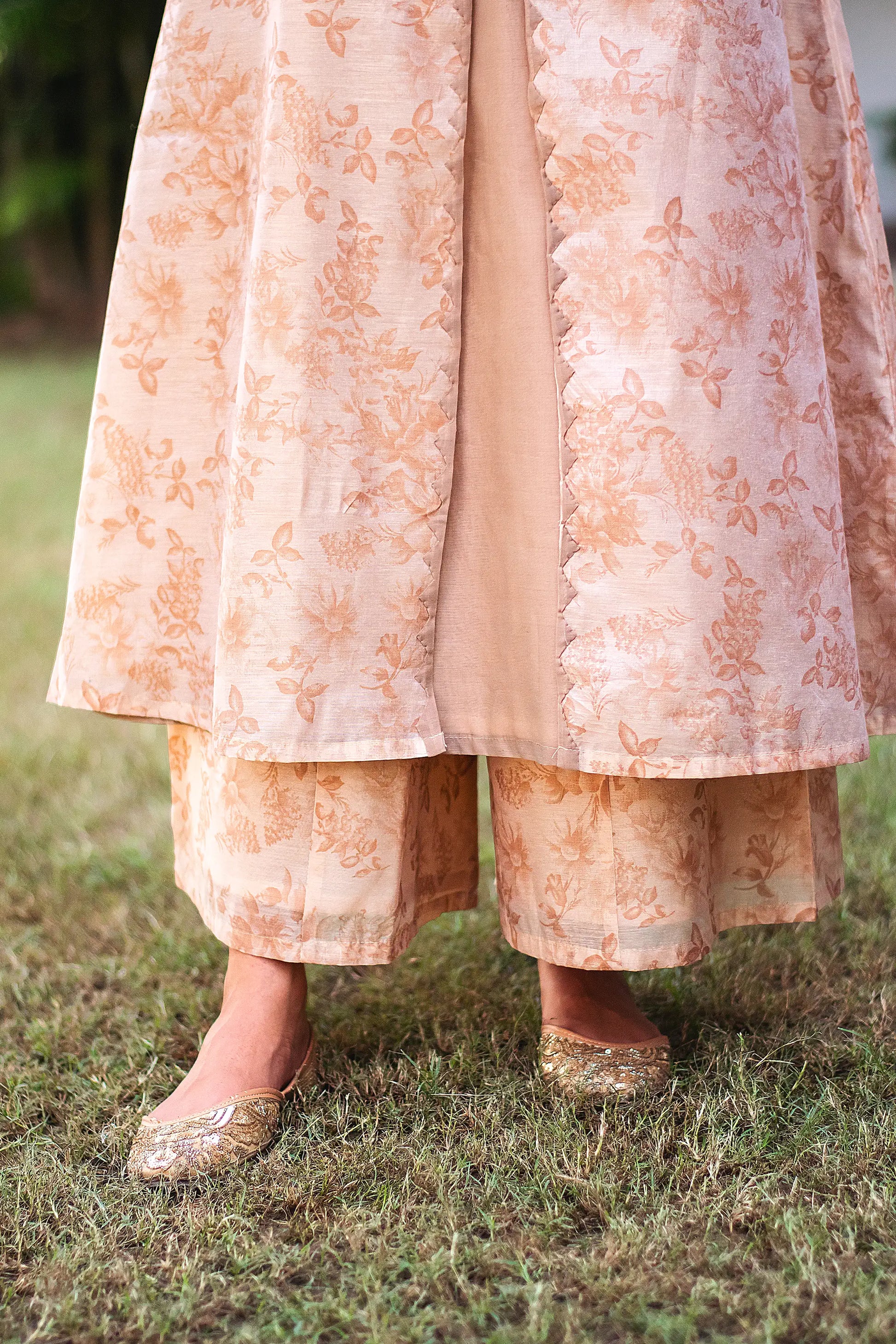 Lower half front view of a model wearing the beige floral print kurta set, featuring a beige floral print chanderi angrakha, matching palazzo