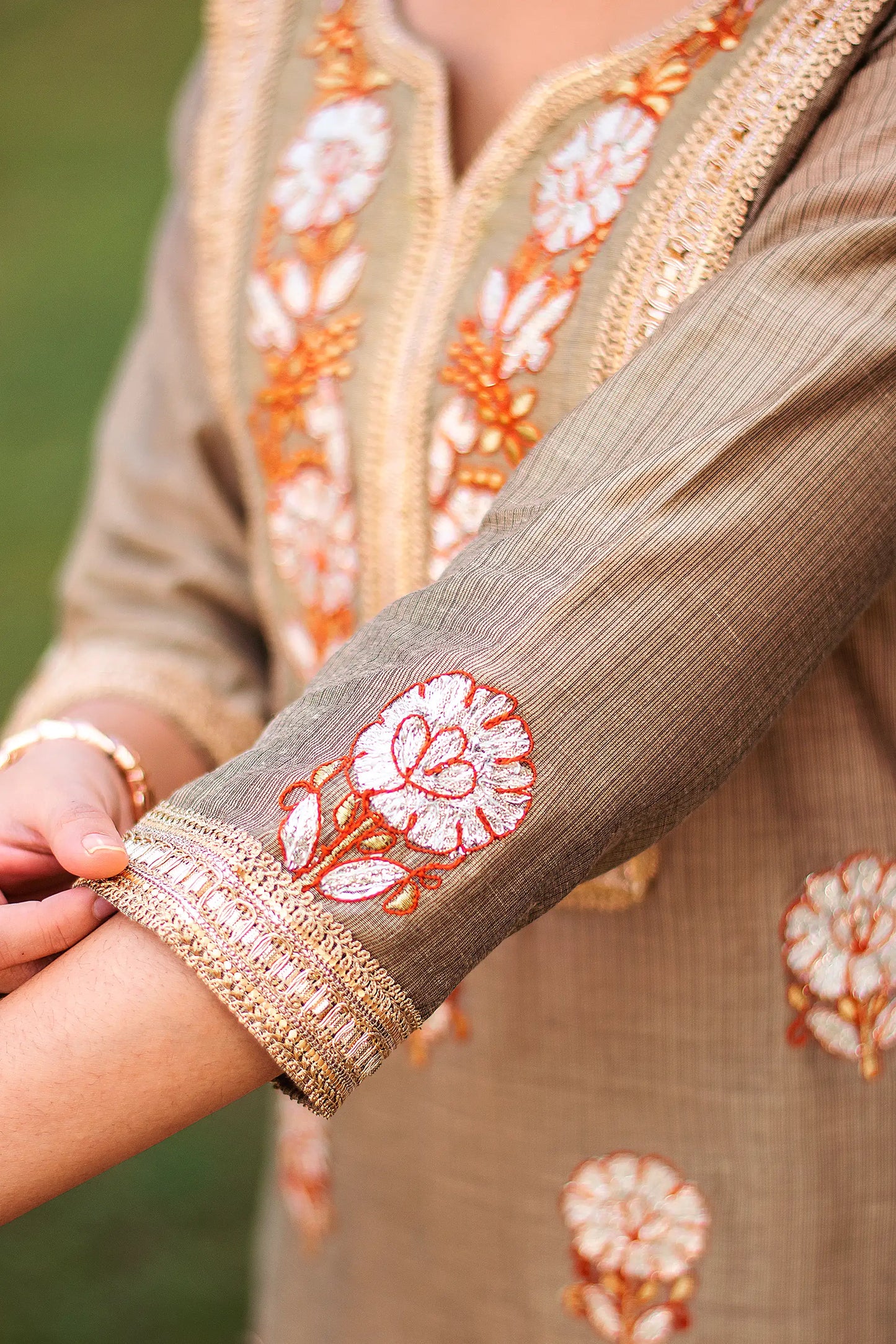 Close-up of the golden gota patti work on the sleeve of the beige Chanderi kurta.