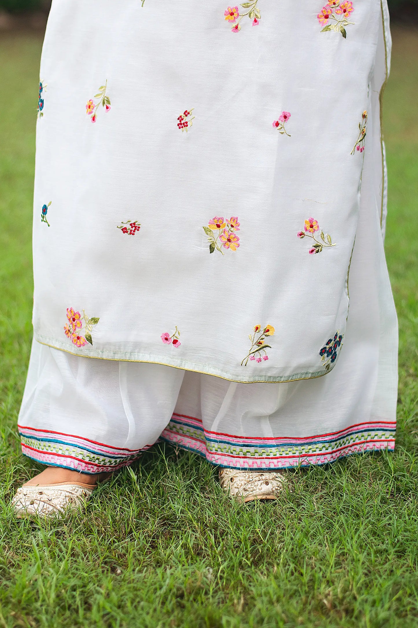 Close-up of the white chanderi palazzo with embroidery at the hem.