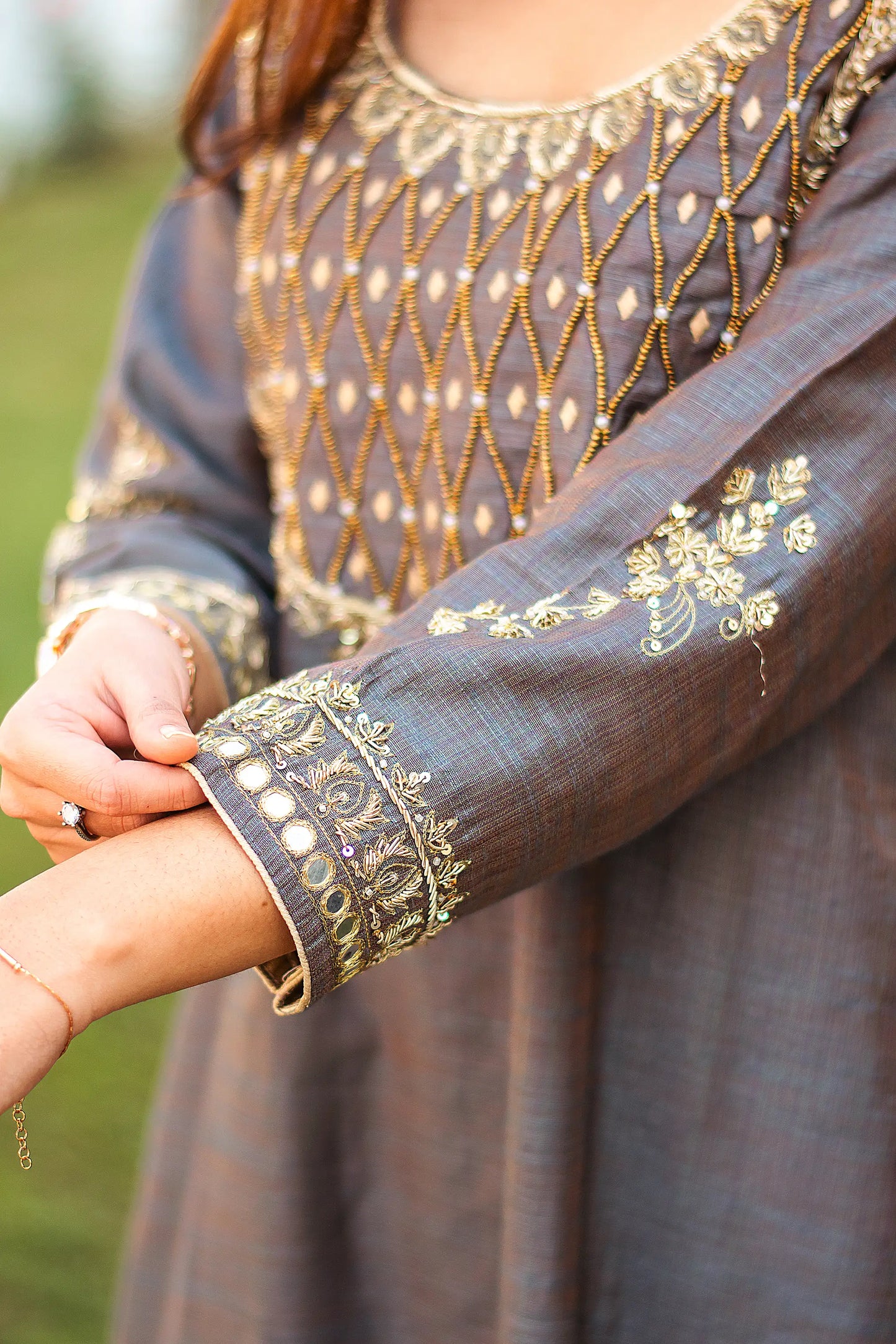 Close-up of the floral zardozi motif on the sleeve of the grey silk kurta.