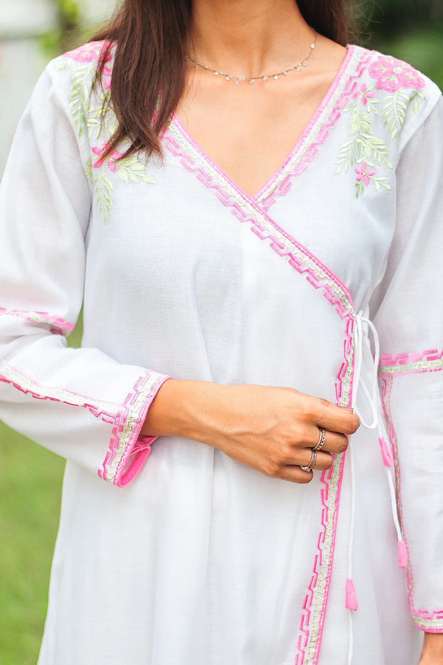 Close-up of the white chanderi angrakha showing intricate pink floral embroidery with green leaves on the yoke.