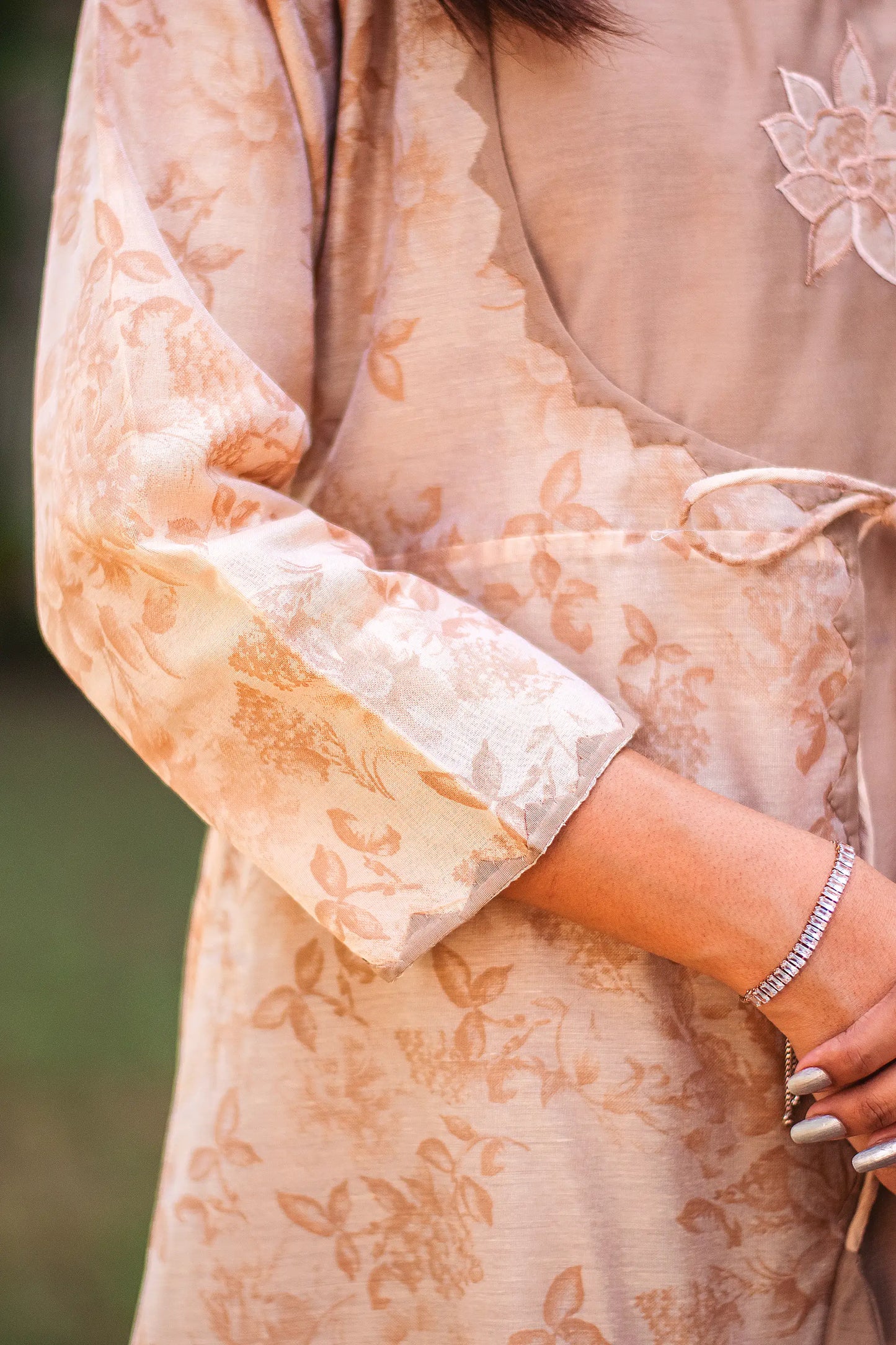 Close-up of the three-quarter sleeves of the angrakha kurta, featuring intricate kikri work and floral print.