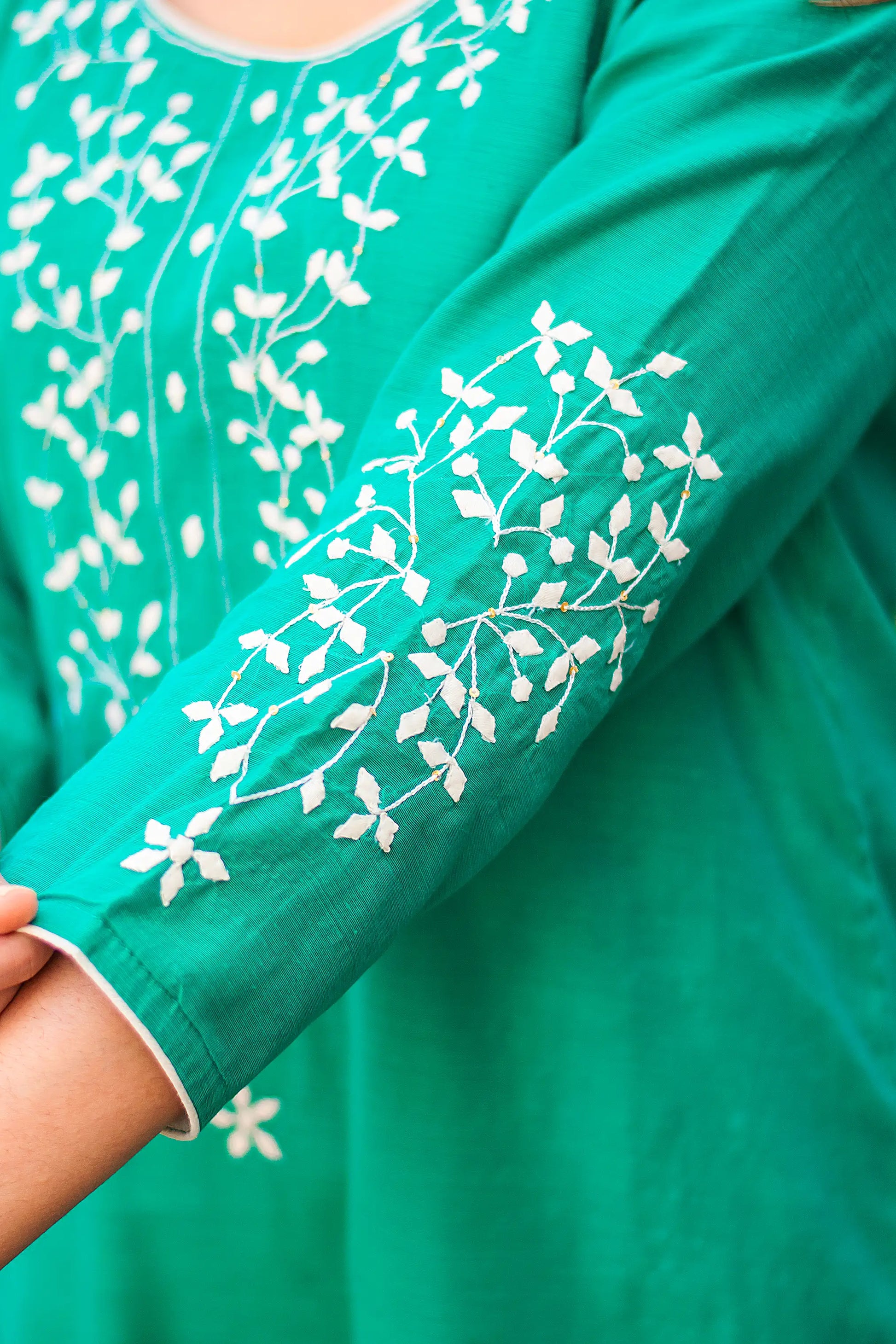 Close up of the sleeve of the green chanderi kurta with applique work.