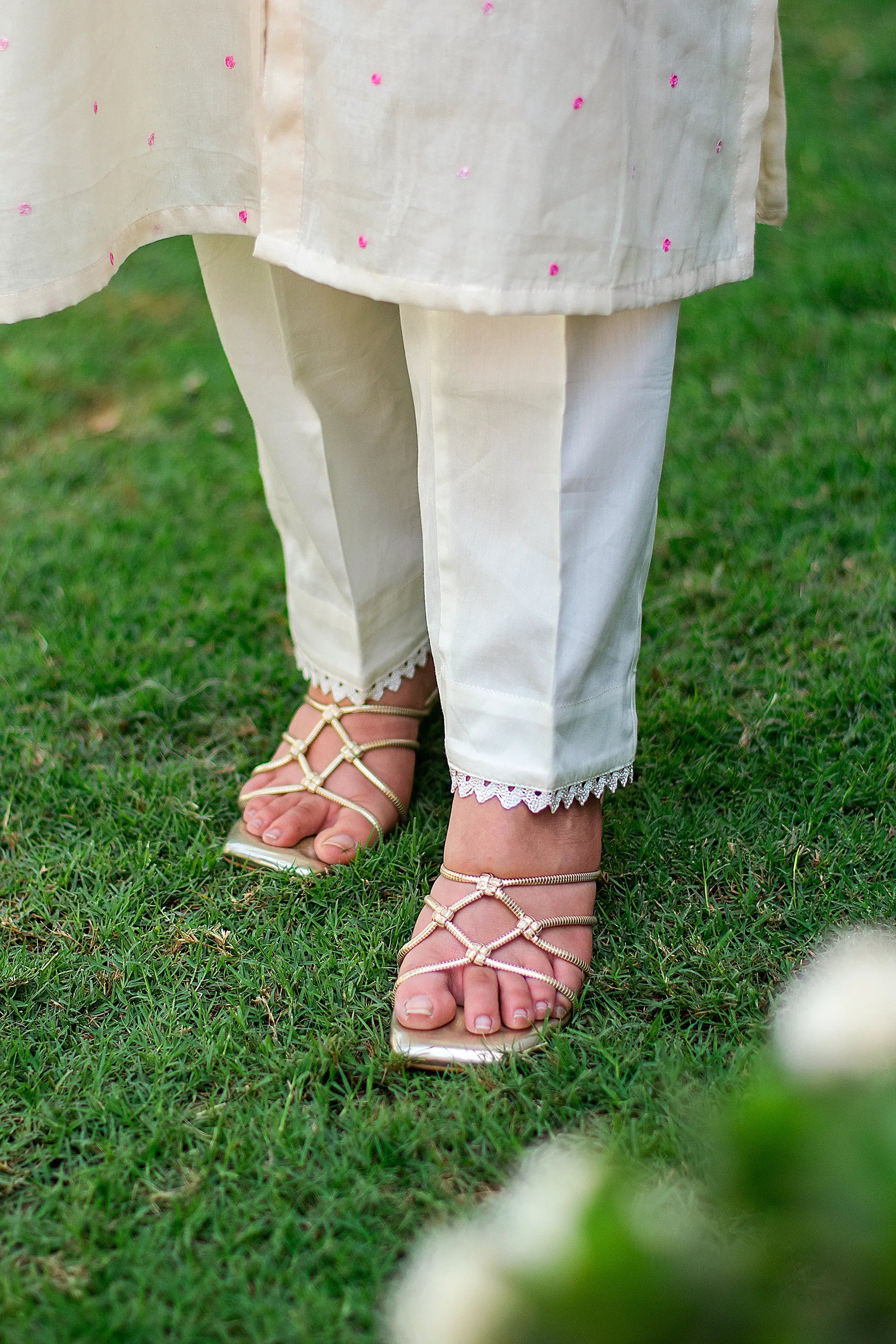 Close-up of an Indian model in plain off-white trousers tailored from Russian silk.