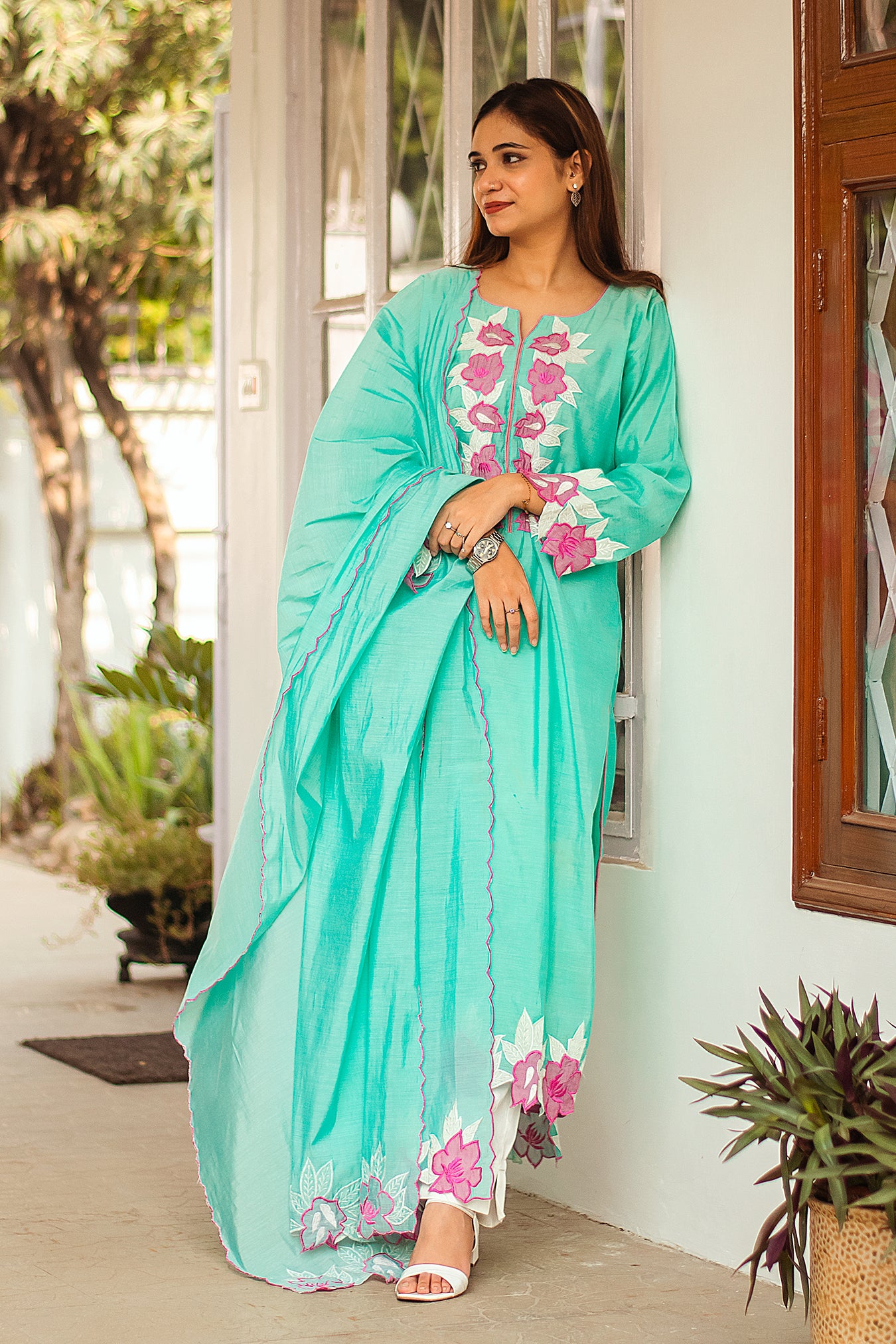 Indian model wearing a blue chanderi kurta and dupatta with purple patchwork flowers, and off-white trousers.