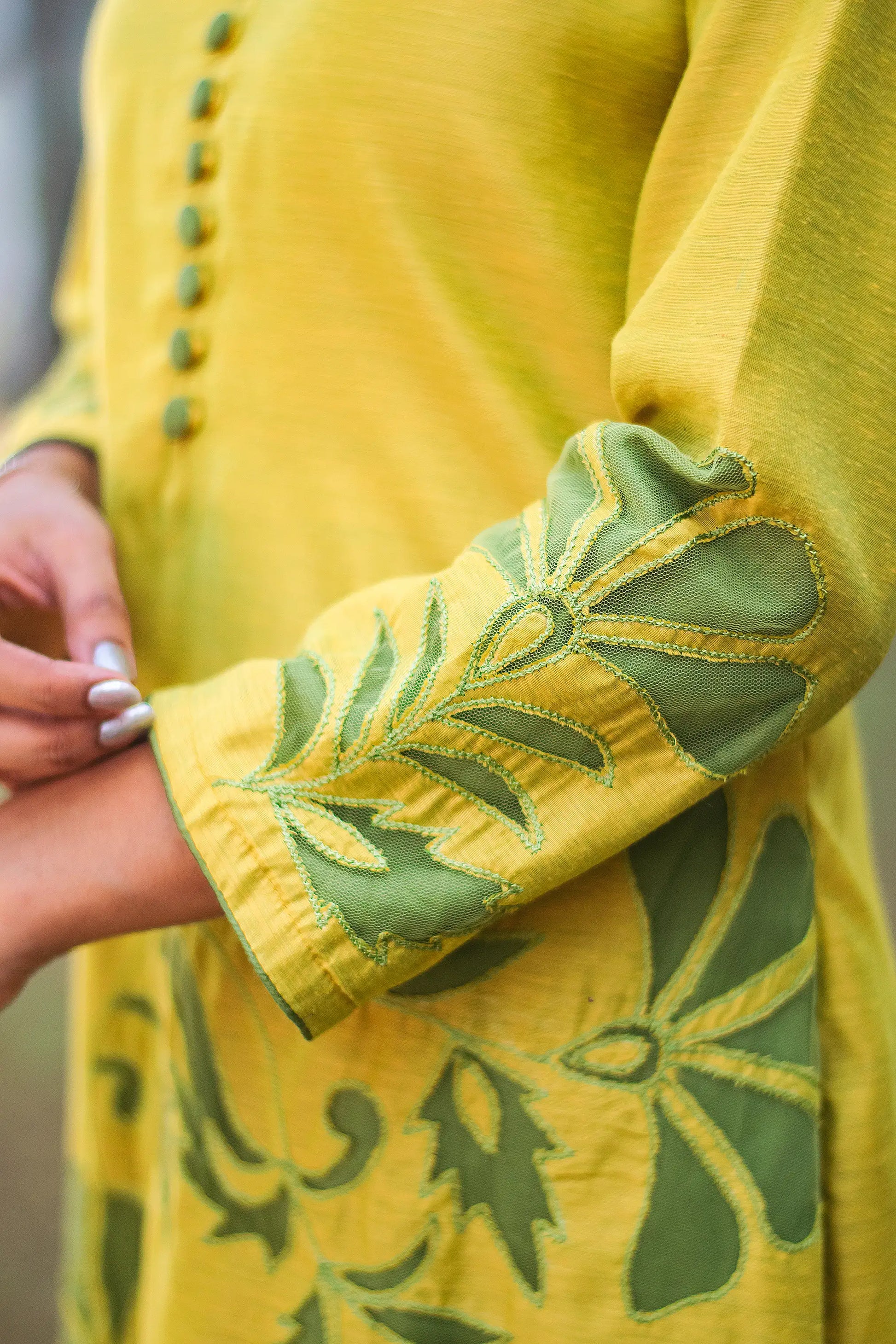 Close-up of the full-length sleeves of the cutwork kurta, featuring the green cutwork design around the cuffs