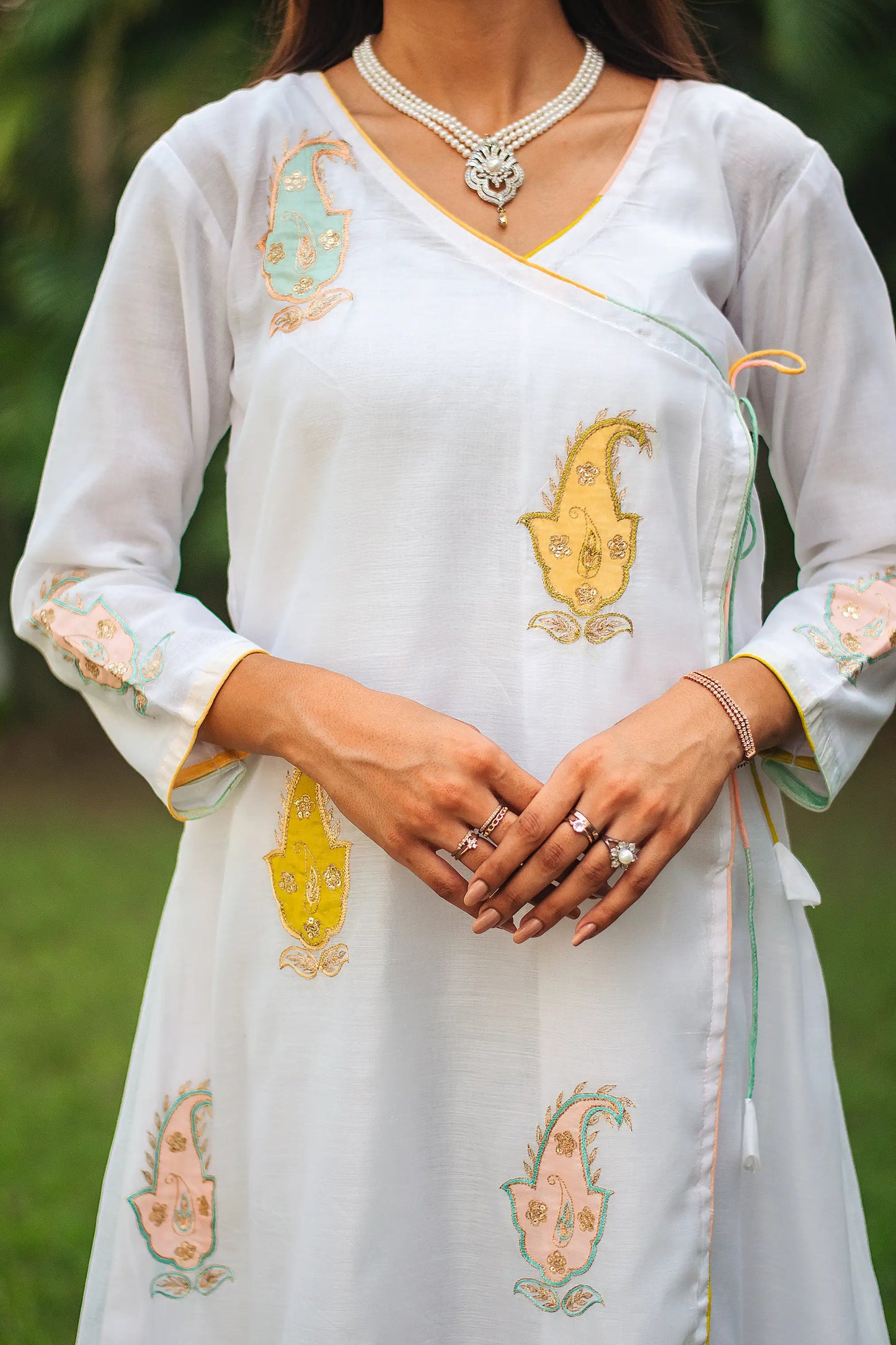 Close-up of the kairi (paisley) patchwork on the yoke of a white chanderi angarkha kurta.