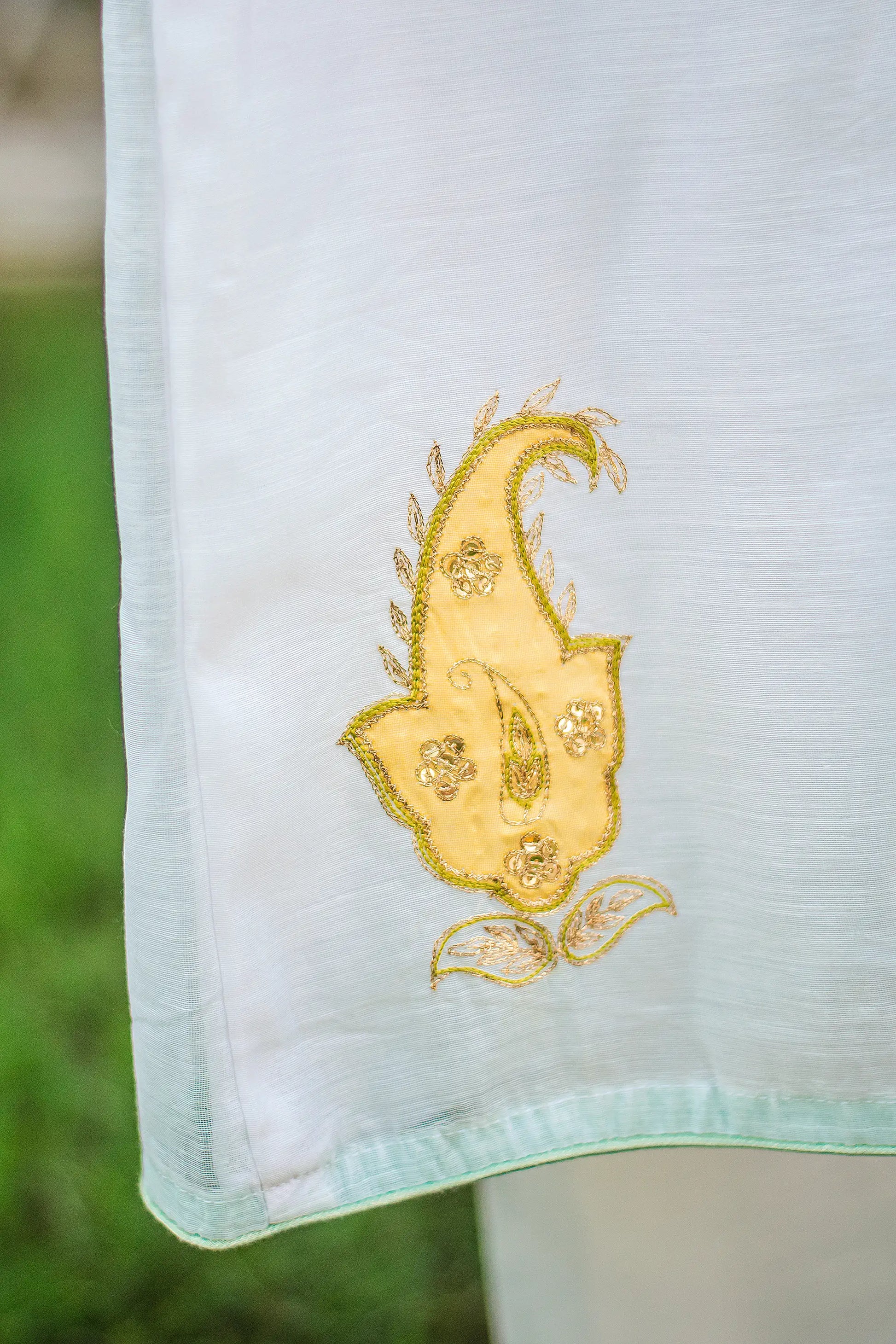 the work on the sleeve	Zoomed-in view of the kairi on the angarkha kurta.