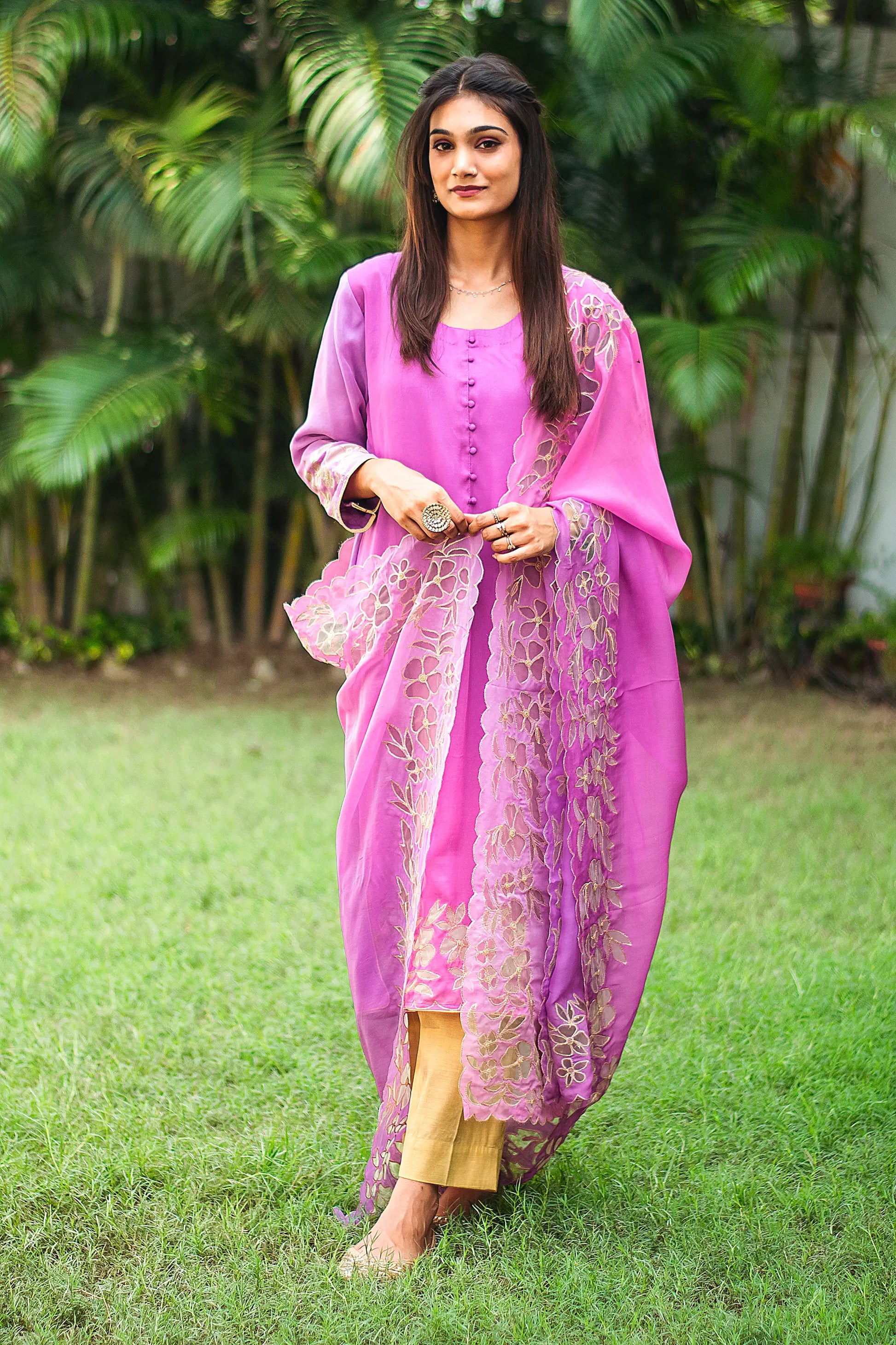 Indian model wearing a light purple organza kurta with golden floral cutwork, paired with a matching cutwork dupatta and gold trousers.