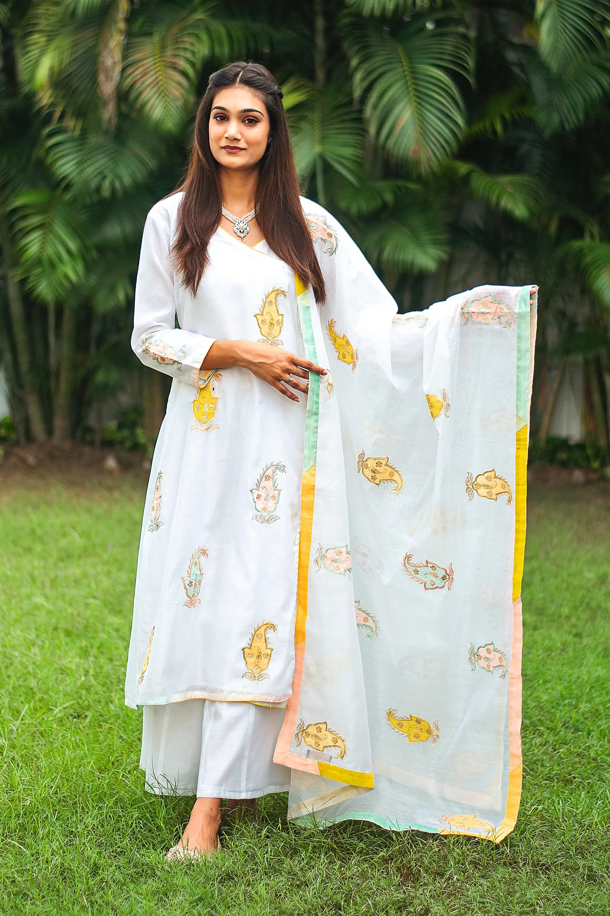 Indian model in a white chanderi angarkha kurta and dupatta featuring kairi (paisley) patchwork, paired with a white chanderi palazzo.