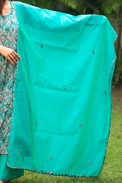 Indian model holding a green chanderi dupatta with intricate applique kikri motifs and delicate applique flowers scattered across the fabric.