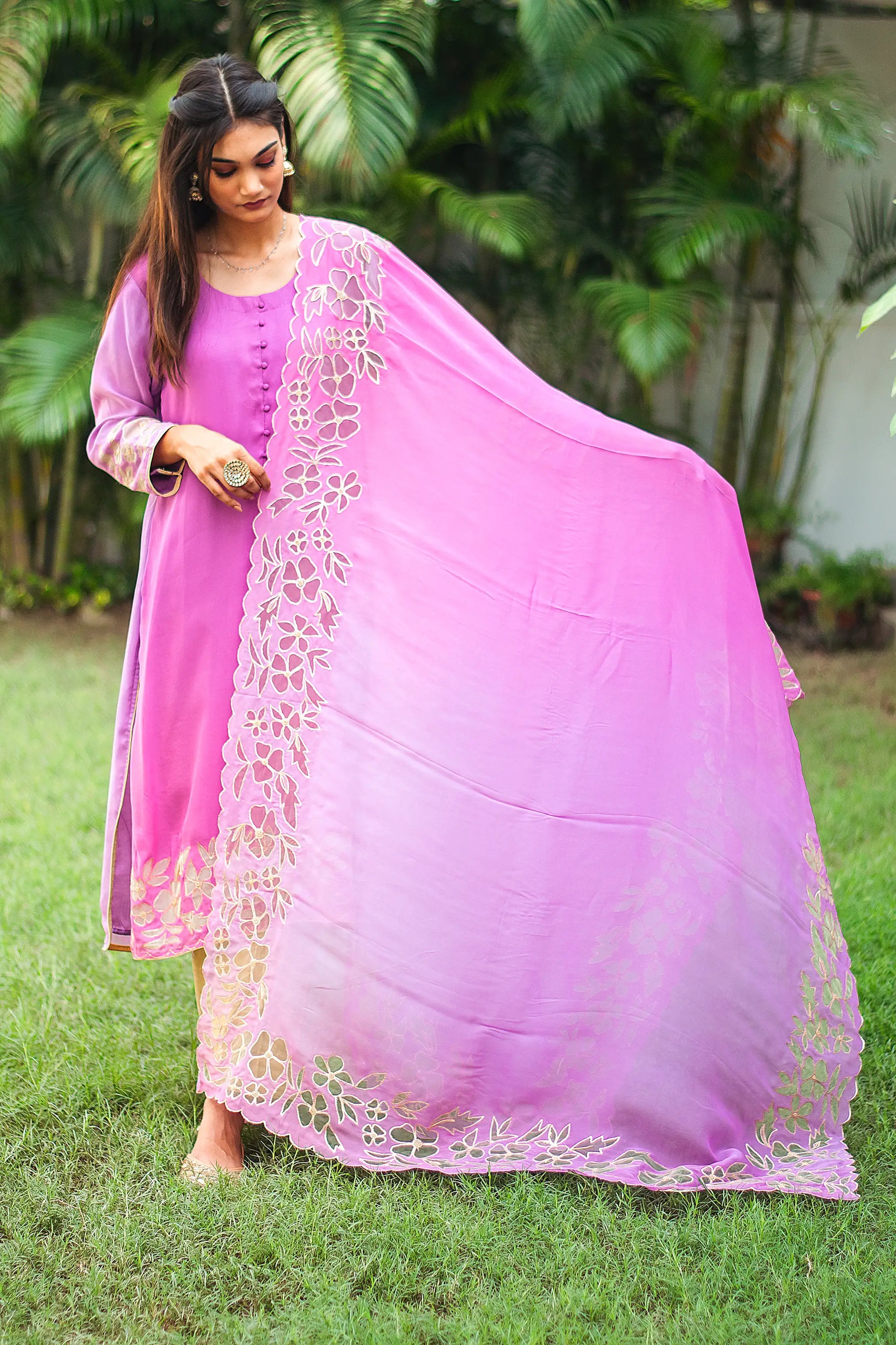 Indian model holding a light purple organza dupatta with golden floral cutwork along the borders.