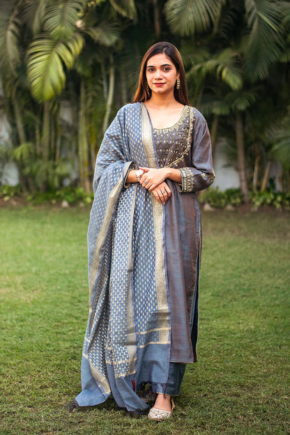 Indian model in a grey silk kurta with golden zardozi work, paired with a matching grey chanderi dupatta and palazzo.