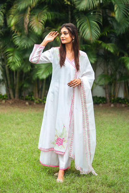 Indian model dressed in a white chanderi angrakha and dupatta adorned with pink and green embroidery and white chanderi palazzo