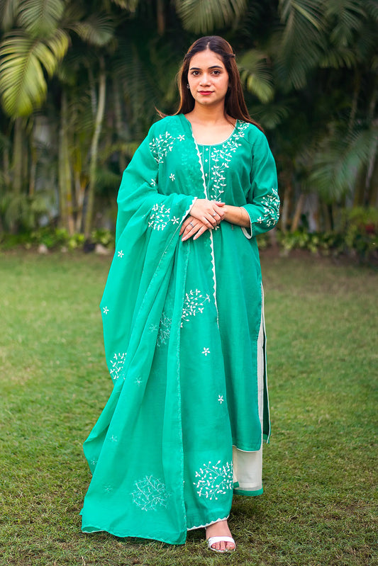 An Indian model in a green Chanderi kurti with applique work, white palazzo pants, and a matching dupatta.