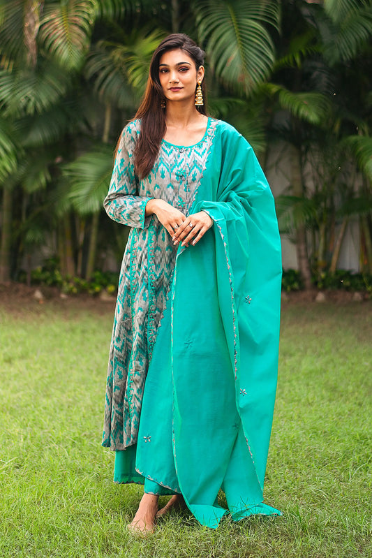 Indian model in a grey and green ikat print kurta with green applique work, paired with a matching green dupatta and palazzo.