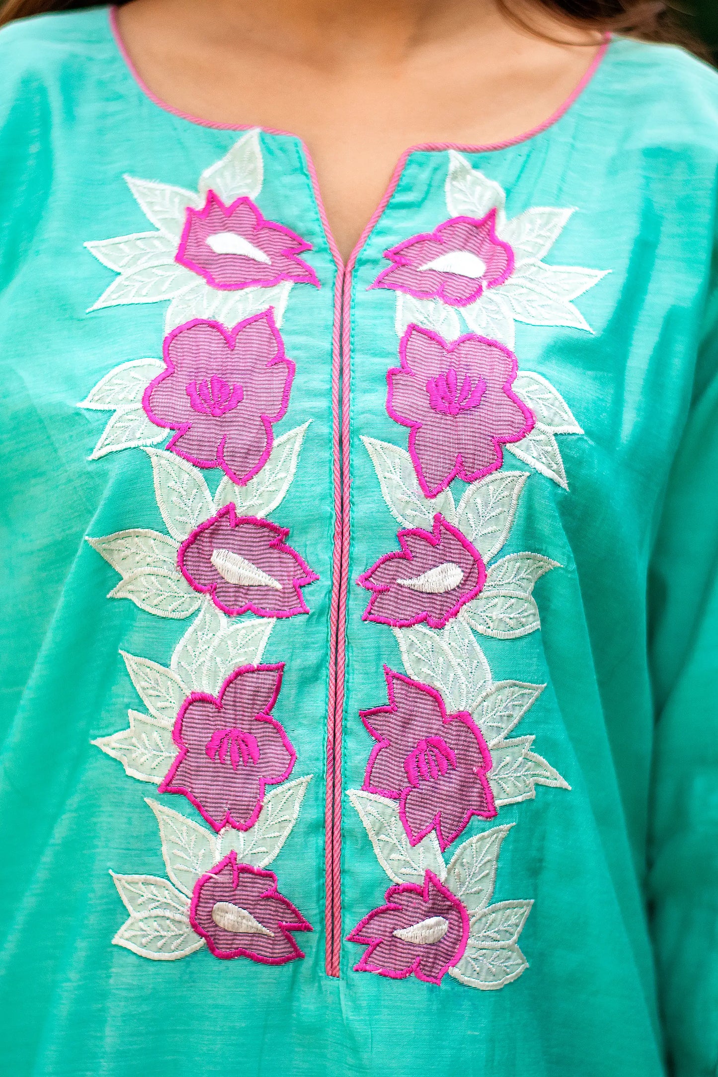 Close-up of purple patchwork flowers on the yoke of a blue chanderi kurta.